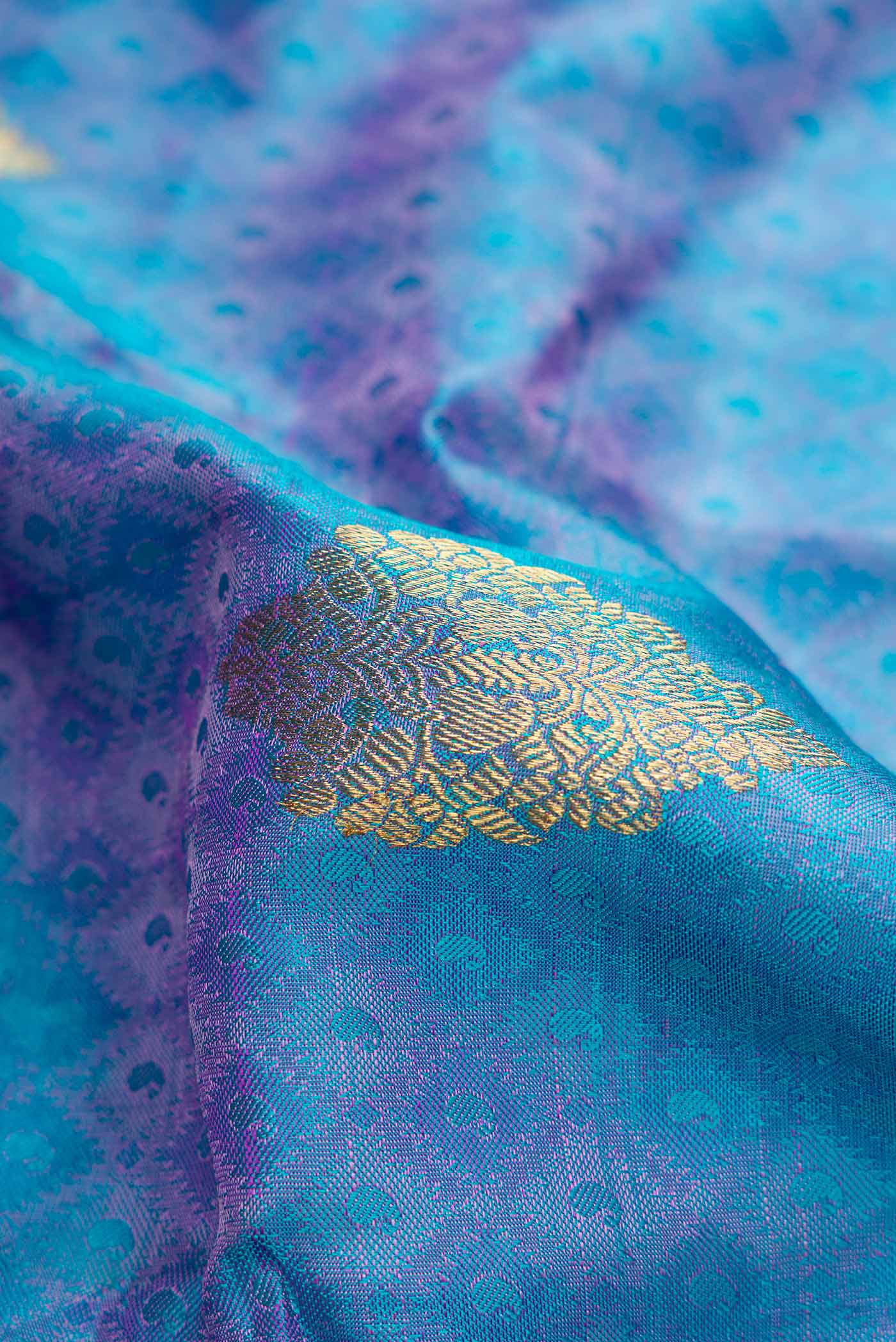 Close up of Pure Silk Pure Zari Peacock Blue Dual Tone Kanchipuram Saree with Jacquard With Zari Butta on the body and Zari Border.  displaying folds