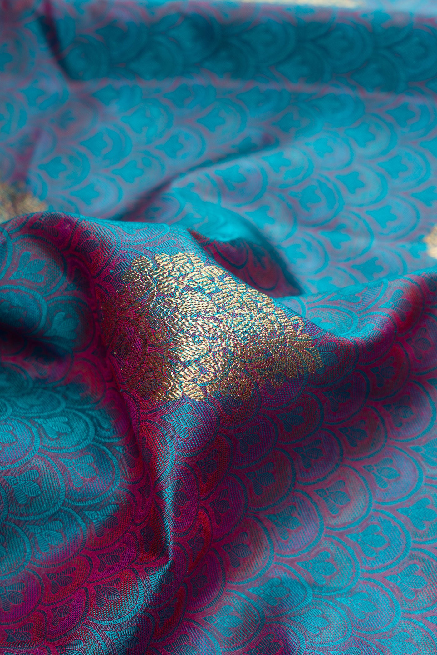 Close up of Pure Silk Pure Zari Peacock Blue Dual Tone Kanchipuram Saree with Jacquard With Zari Butta on the body and Zari Border.  displaying folds