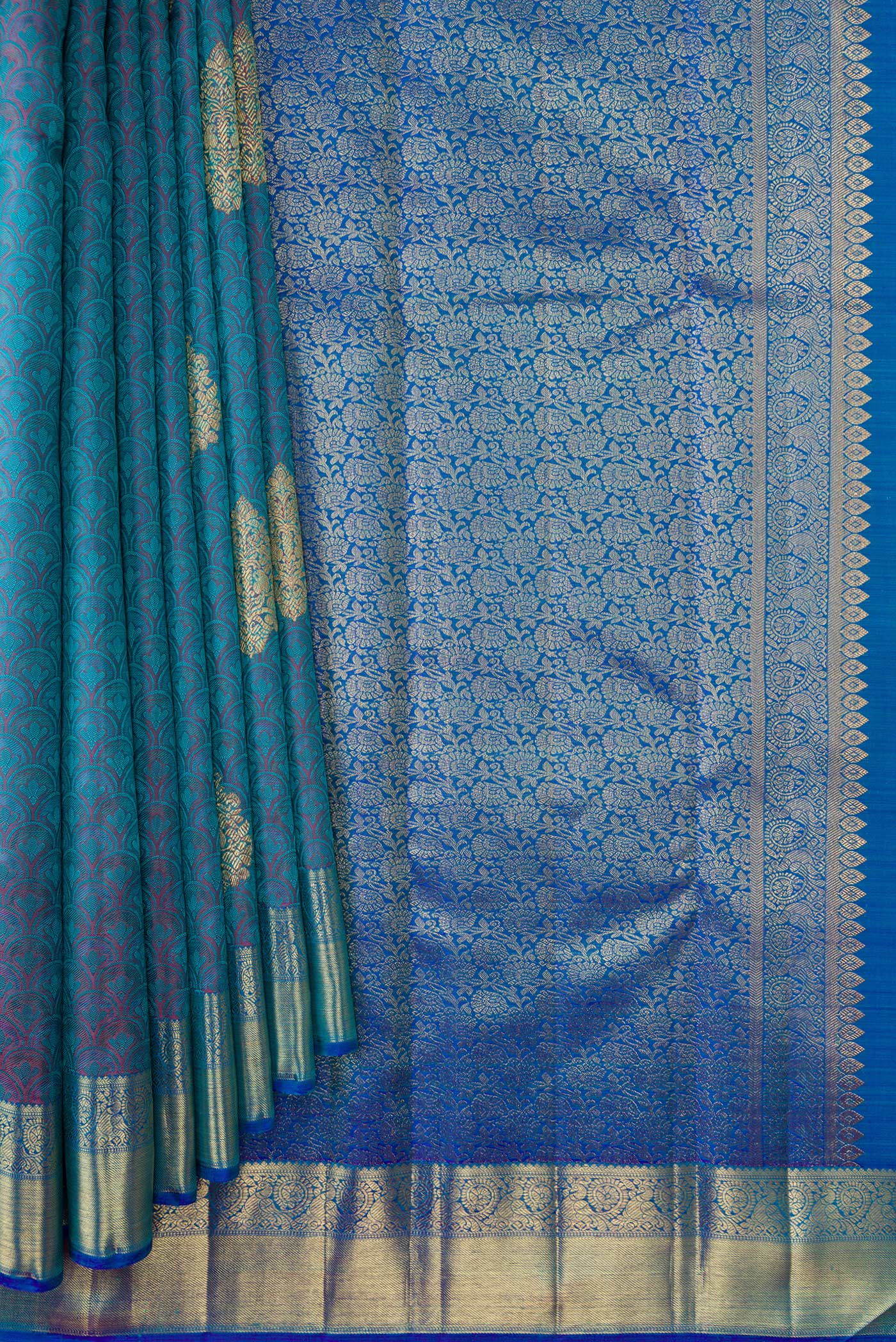 Pleats and pallu of Pure Silk Pure Zari Peacock Blue Dual Tone Kanchipuram Saree with Jacquard With Zari Butta on the body and Zari Border. 