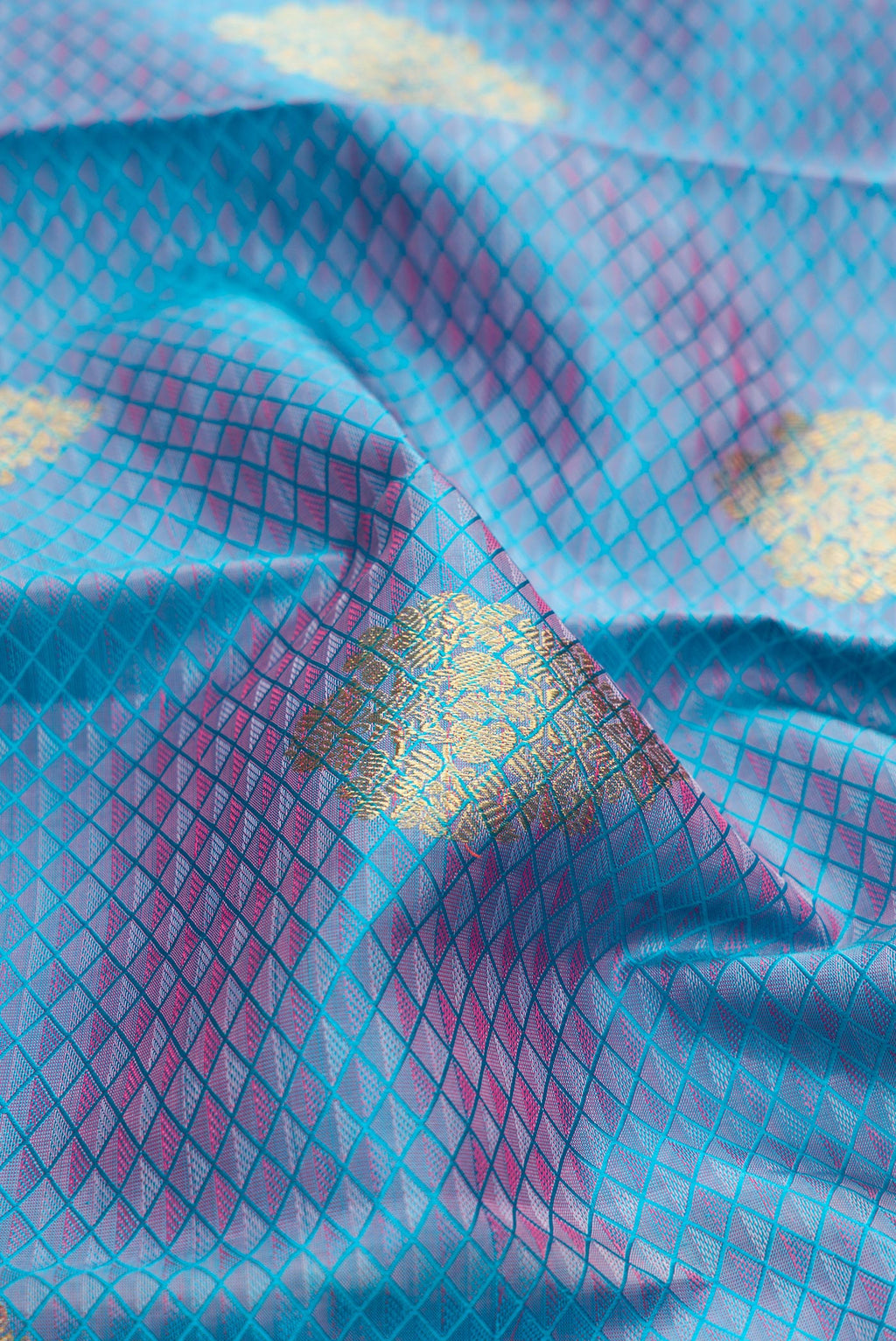 Close up of Pure Silk Pure Zari Light Blue Dual Tone Kanchipuram Saree with Jacquard With Zari Butta on the body and Zari Border.  displaying folds