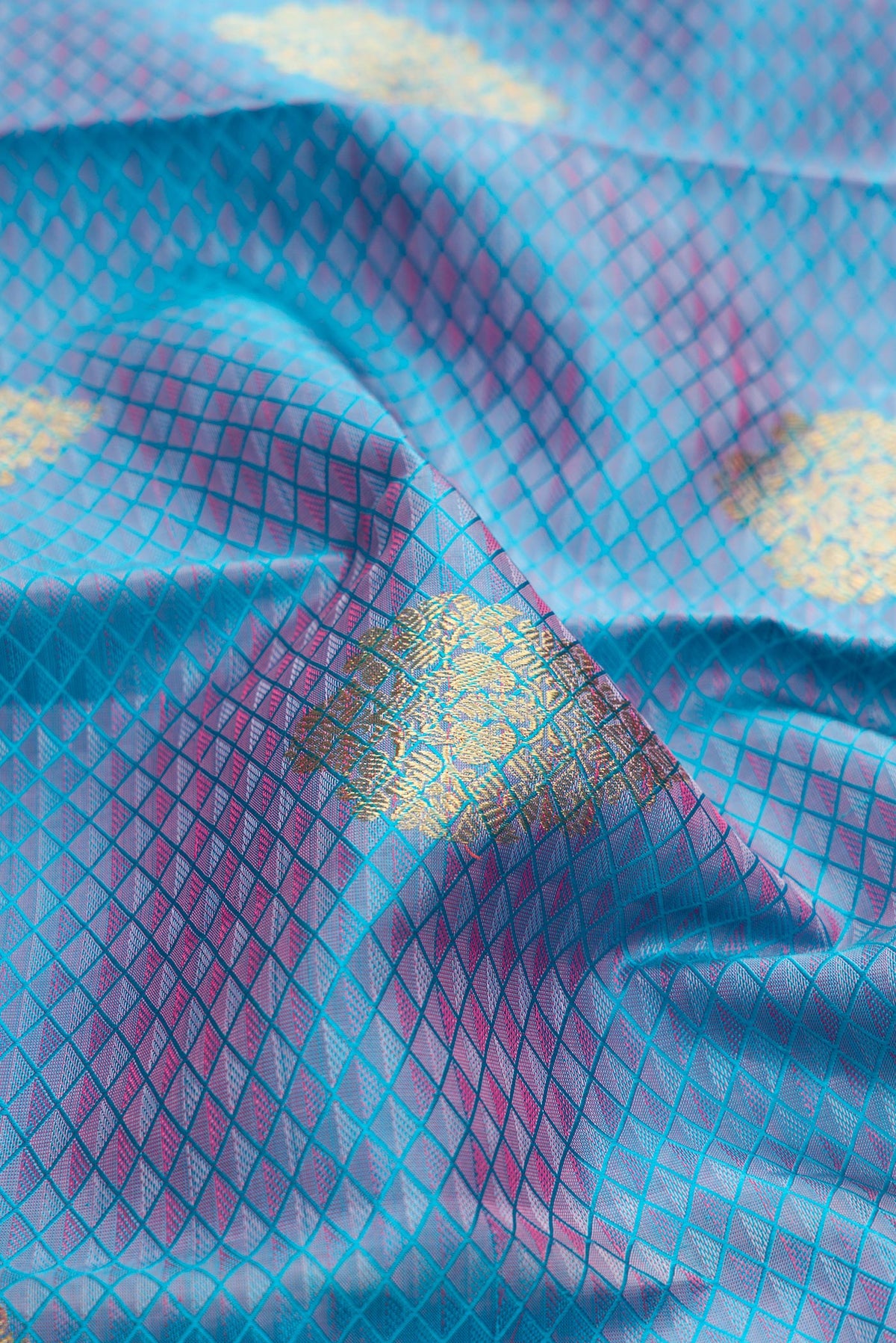 Close up of Pure Silk Pure Zari Light Blue Dual Tone Kanchipuram Saree with Jacquard With Zari Butta on the body and Zari Border.  displaying folds