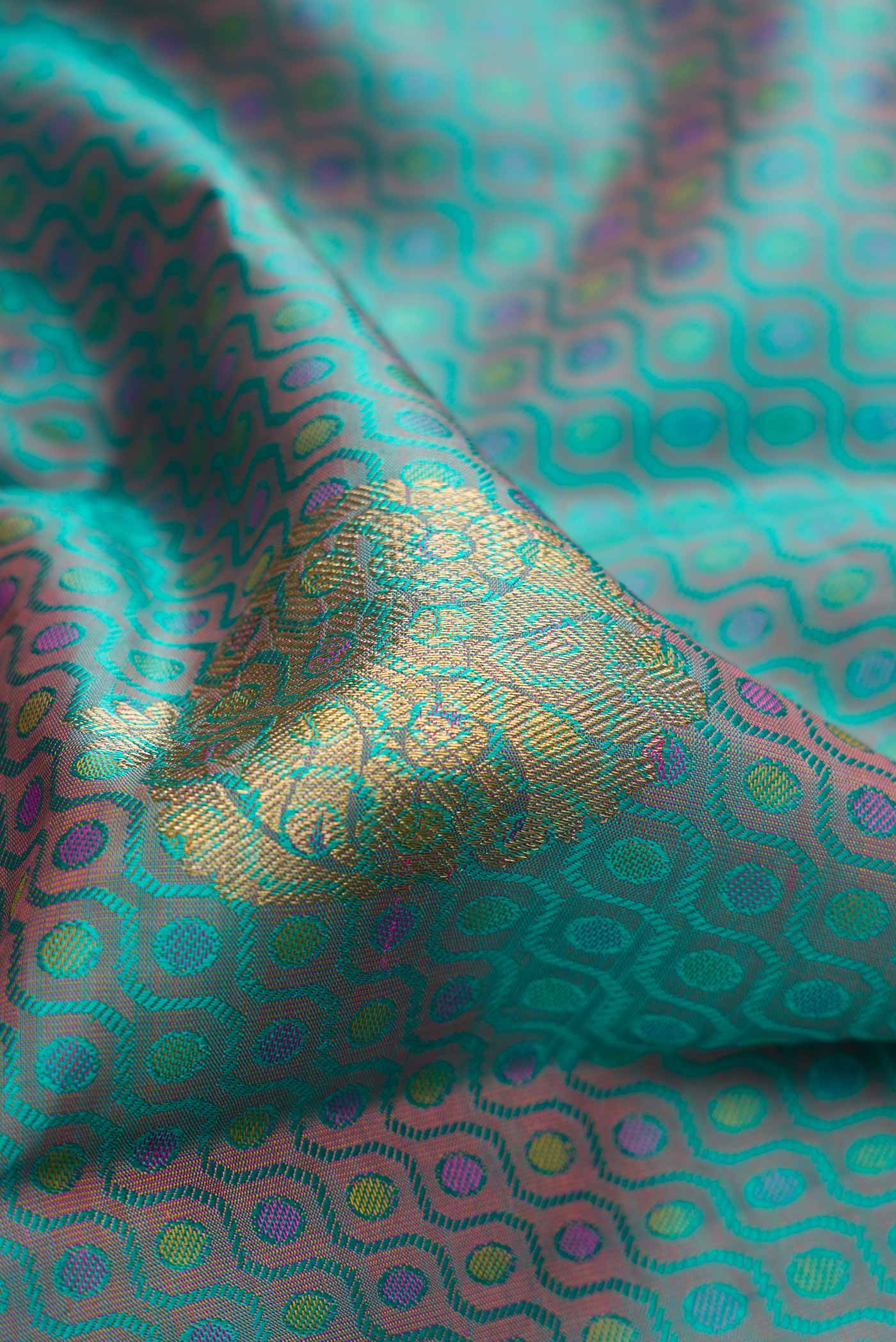 Close up of Pure Silk Pure Zari Peacock Blue Dual Tone Kanchipuram Saree with Jacquard With Zari Butta on the body and Zari Border.  displaying folds