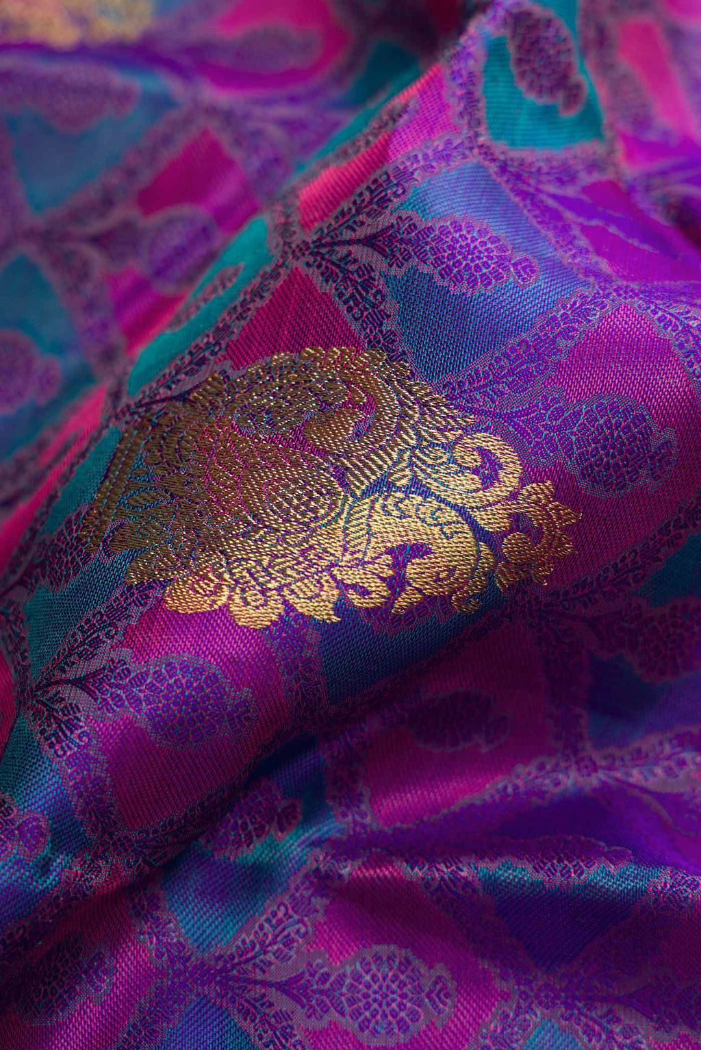 Close up of Pure Silk Pure Zari Purple Dual Tone Kanchipuram Saree with Jacquard With Zari Butta on the body and Zari Border.  displaying folds