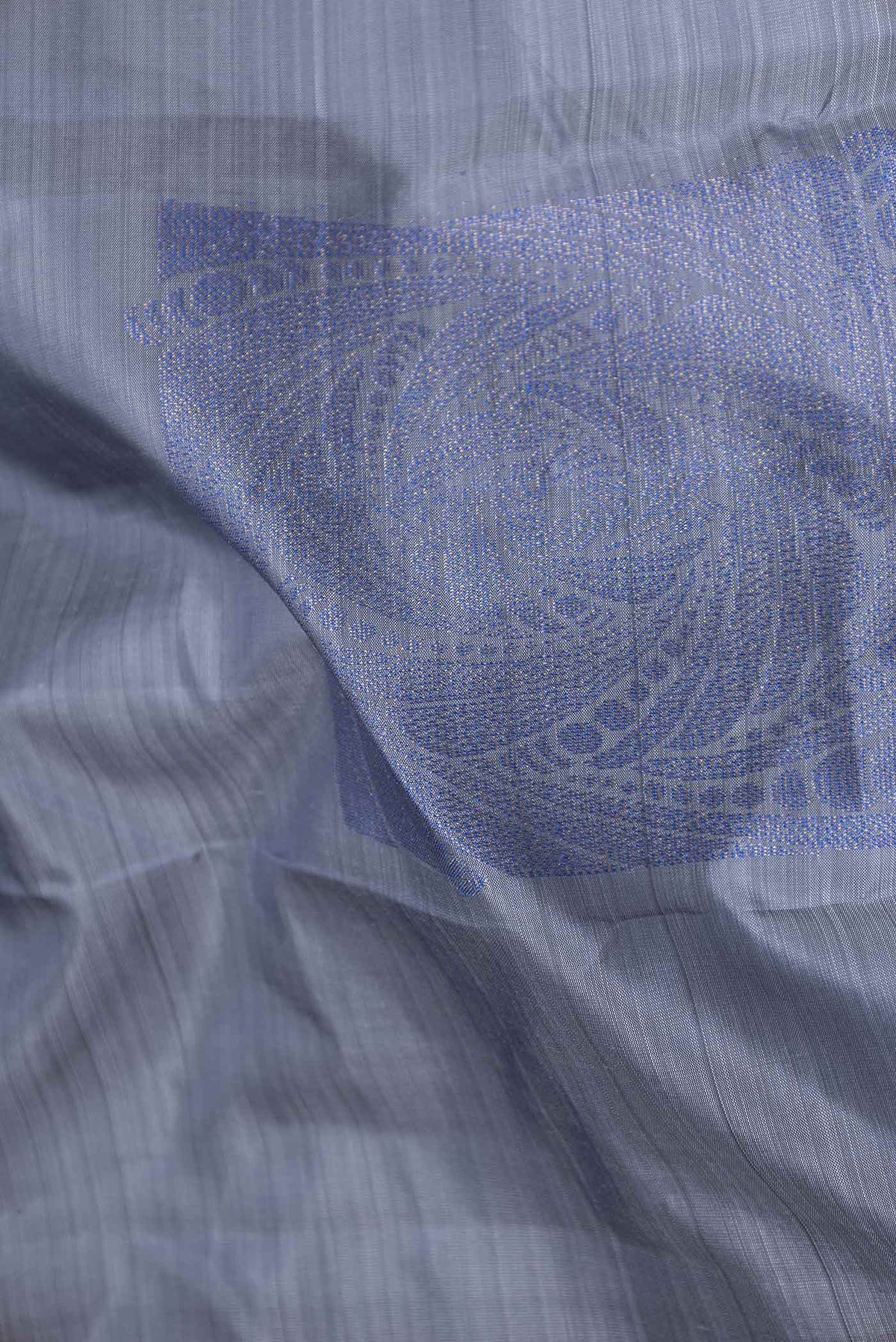 Close up of Grey Dual Tone Kanchipuram Saree with Zari Butta on the body and Without Border displaying folds