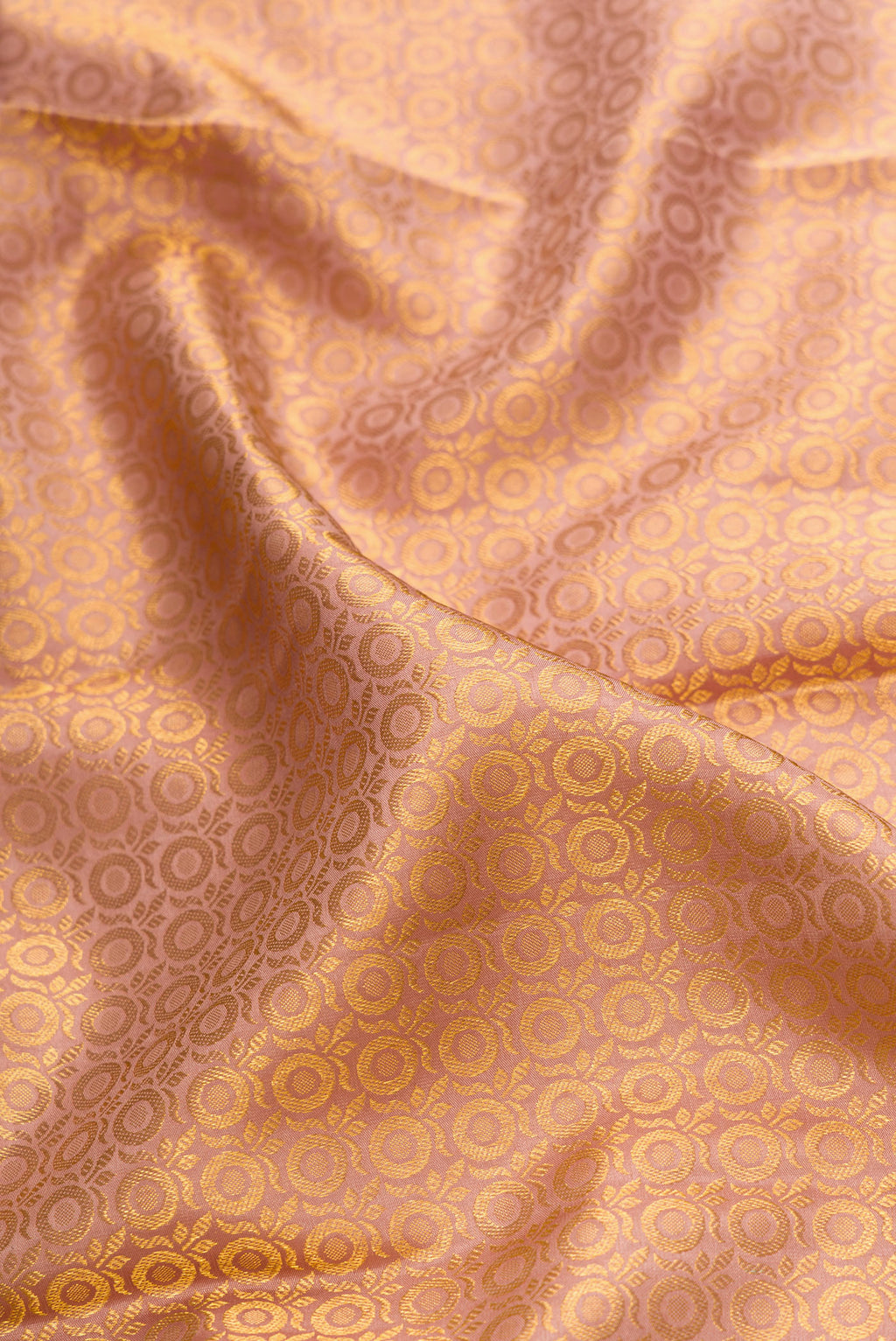 Close up of Rose Gold Dual Tone Kanchipuram Silk Saree with Zari Brocade on the body and Zari Border.  displaying folds