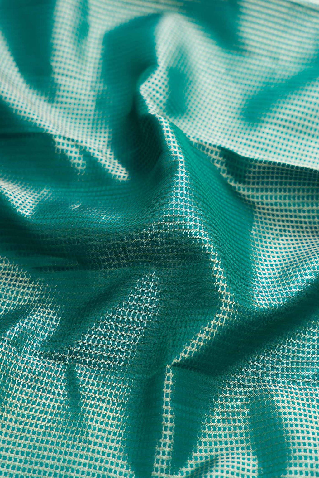 Close up of Peacock Blue Dual Tone Kanchipuram Silk Saree with Zari Brocade on the body and Fancy Border displaying folds