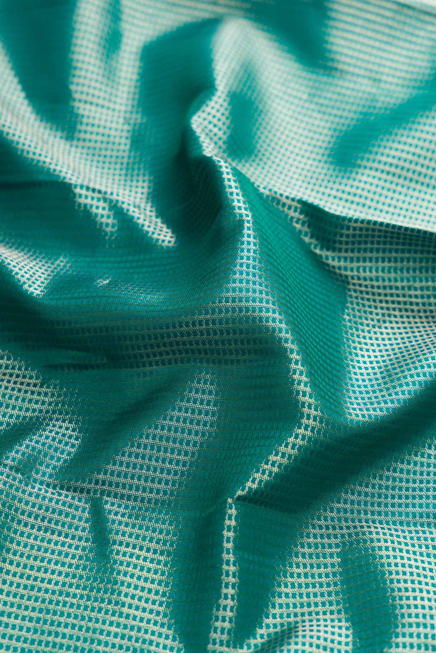 Close up of Peacock Blue Dual Tone Kanchipuram Silk Saree with Zari Brocade on the body and Fancy Border displaying folds