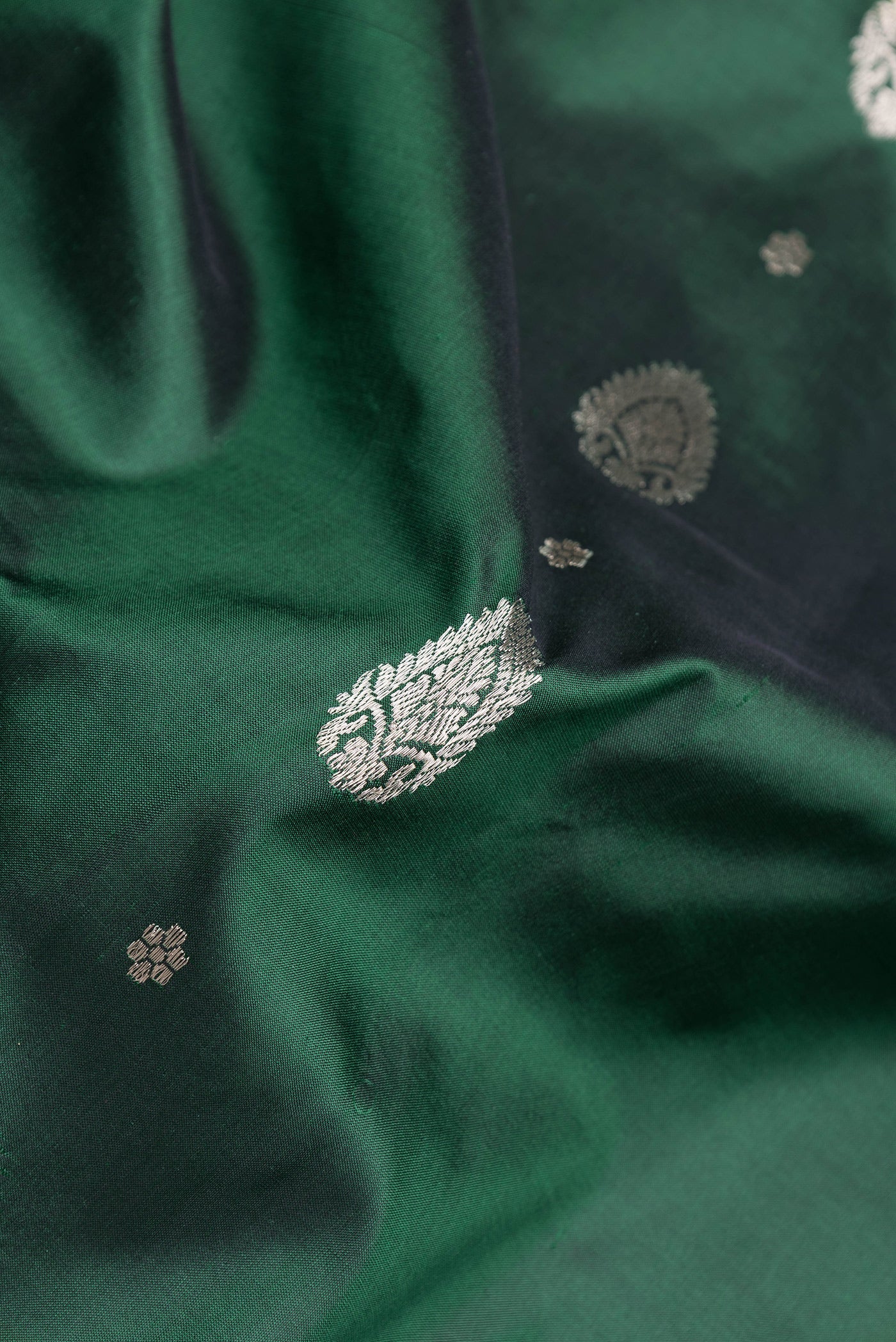 Close up of Bottle Green Dual Tone Banarasi Silk Saree with Zari Butta on the body and Zari Border.  displaying folds