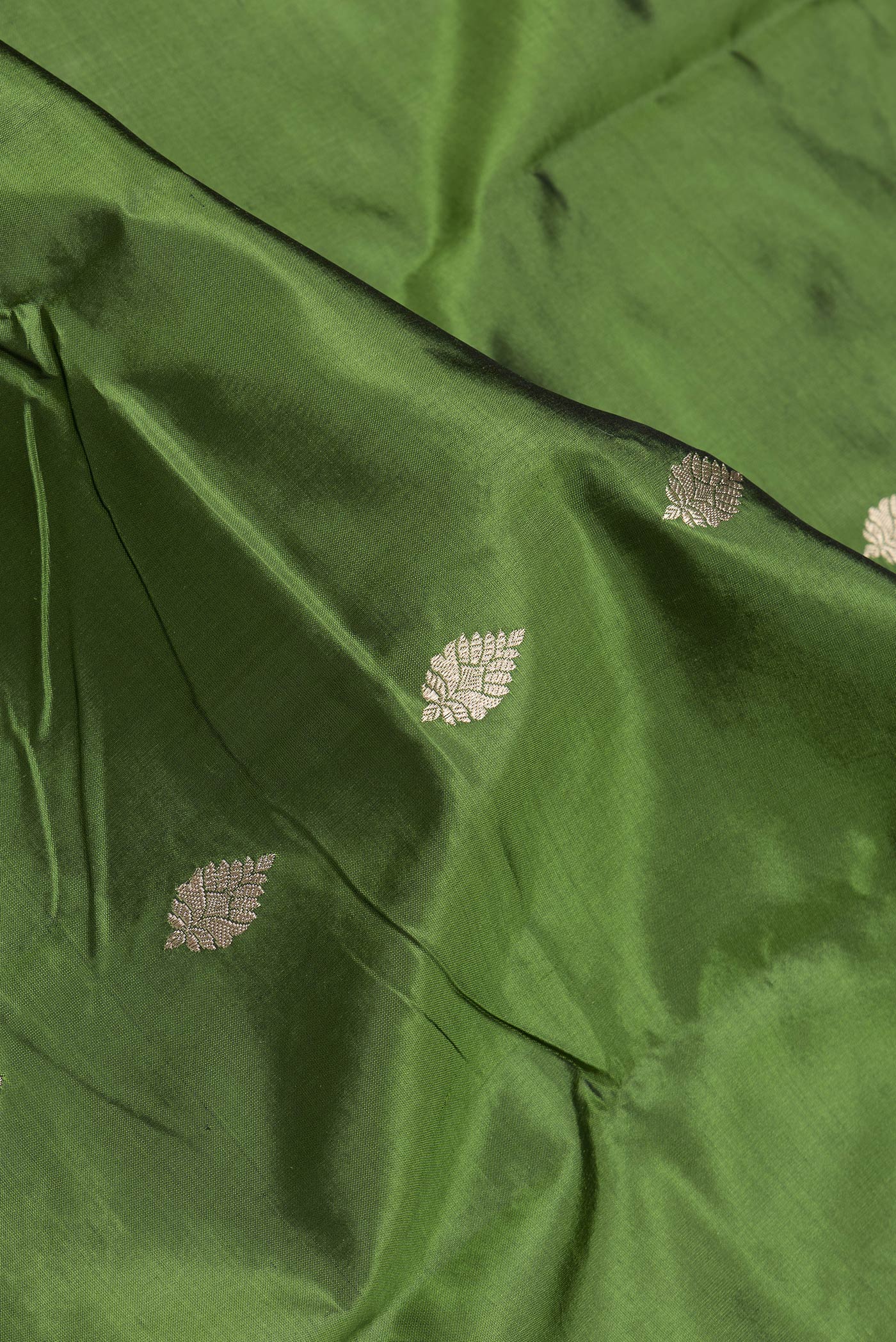Close up of Mehandi Green Dual Tone Banarasi Silk Saree with Zari Butta on the body and Zari Border.  displaying folds