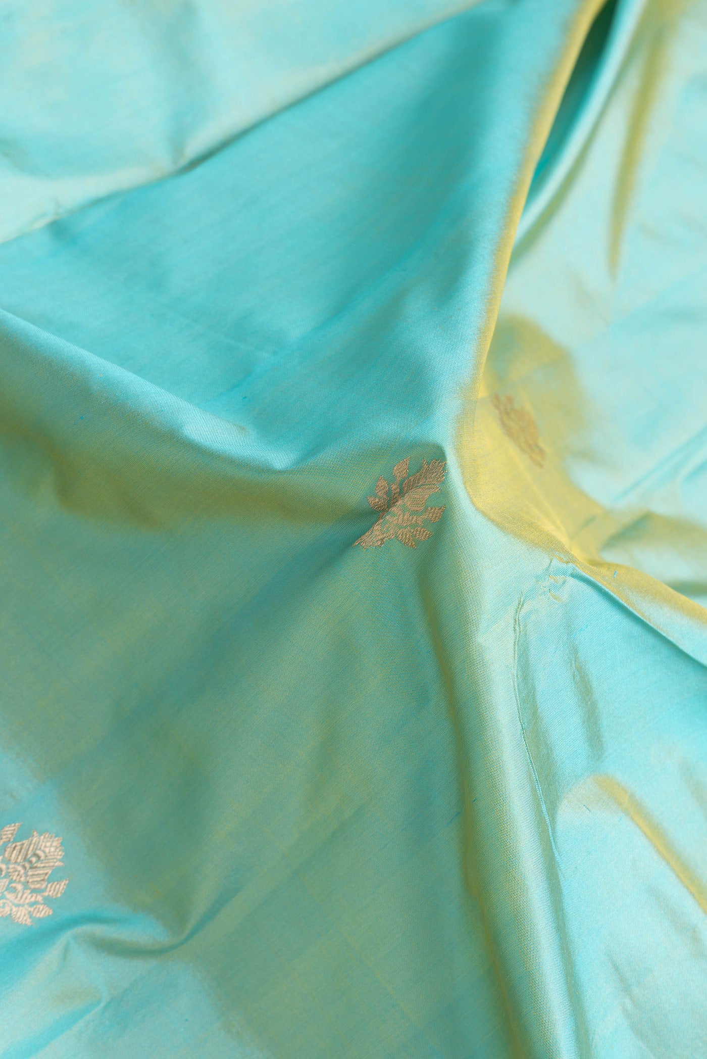 Close up of Sky Blue Dual Tone Banarasi Silk Saree with Zari Butta on the body and Zari Border.  displaying folds
