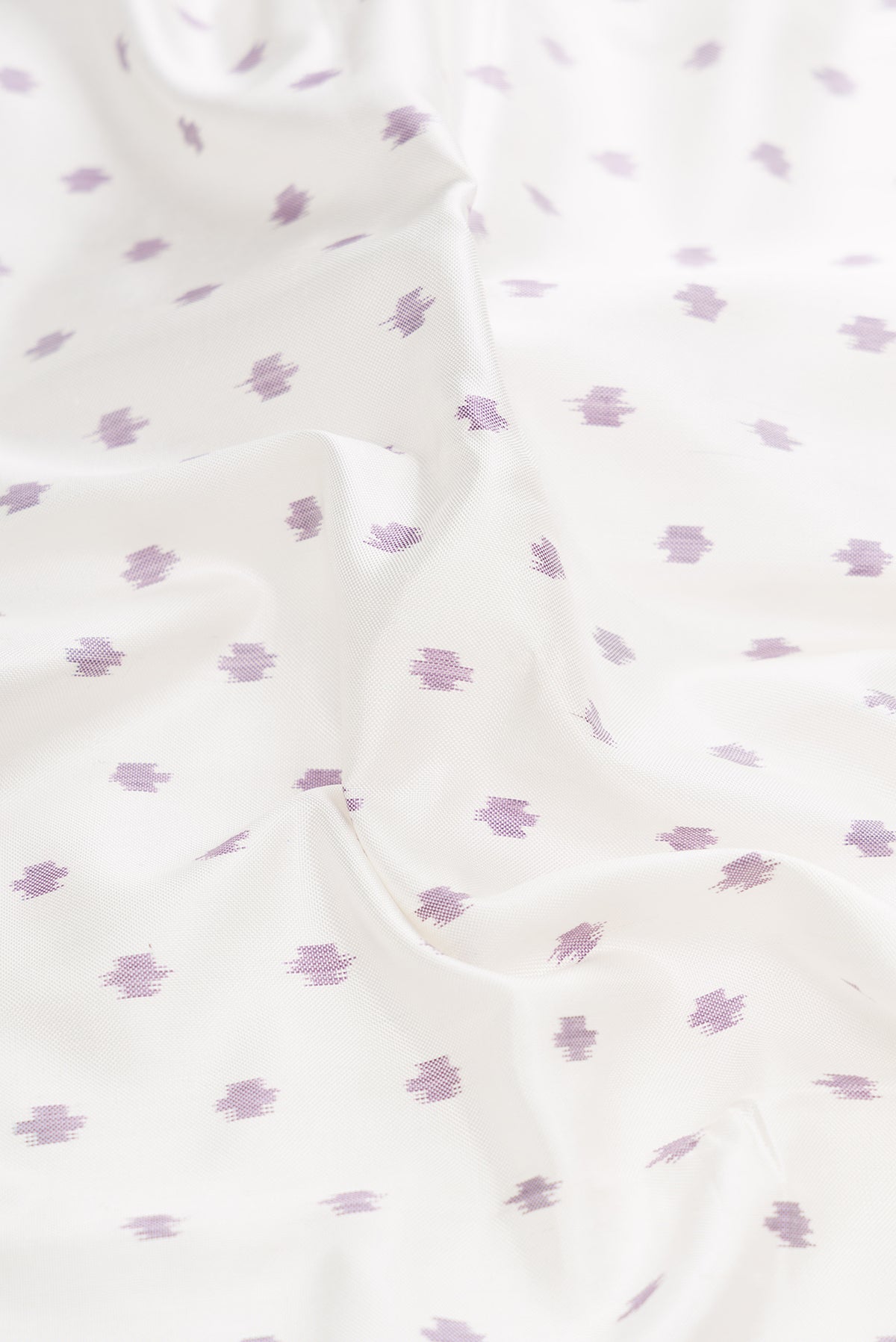 Close up of White Dual Tone Rajkot Patola Silk Saree with Ikat Print on the body and Ikat Border.  displaying folds