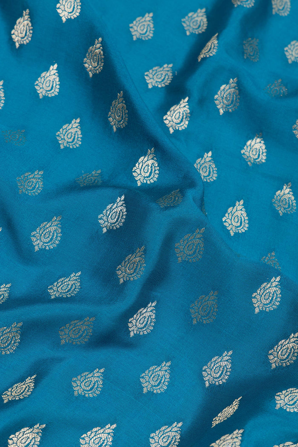 Close up of Peacock Blue Mysore Crepe Saree with Zari Butta on the body and Zari Border.  displaying folds
