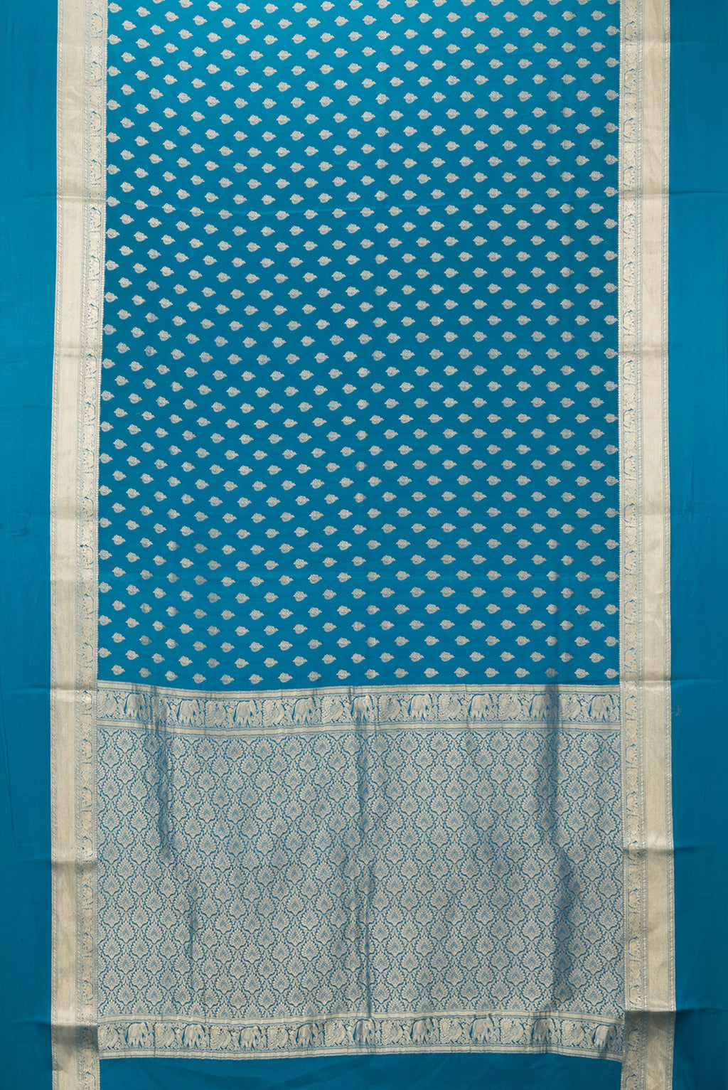 Flat view of Peacock Blue Mysore Crepe Saree with Zari Butta on the body and Zari Border. 