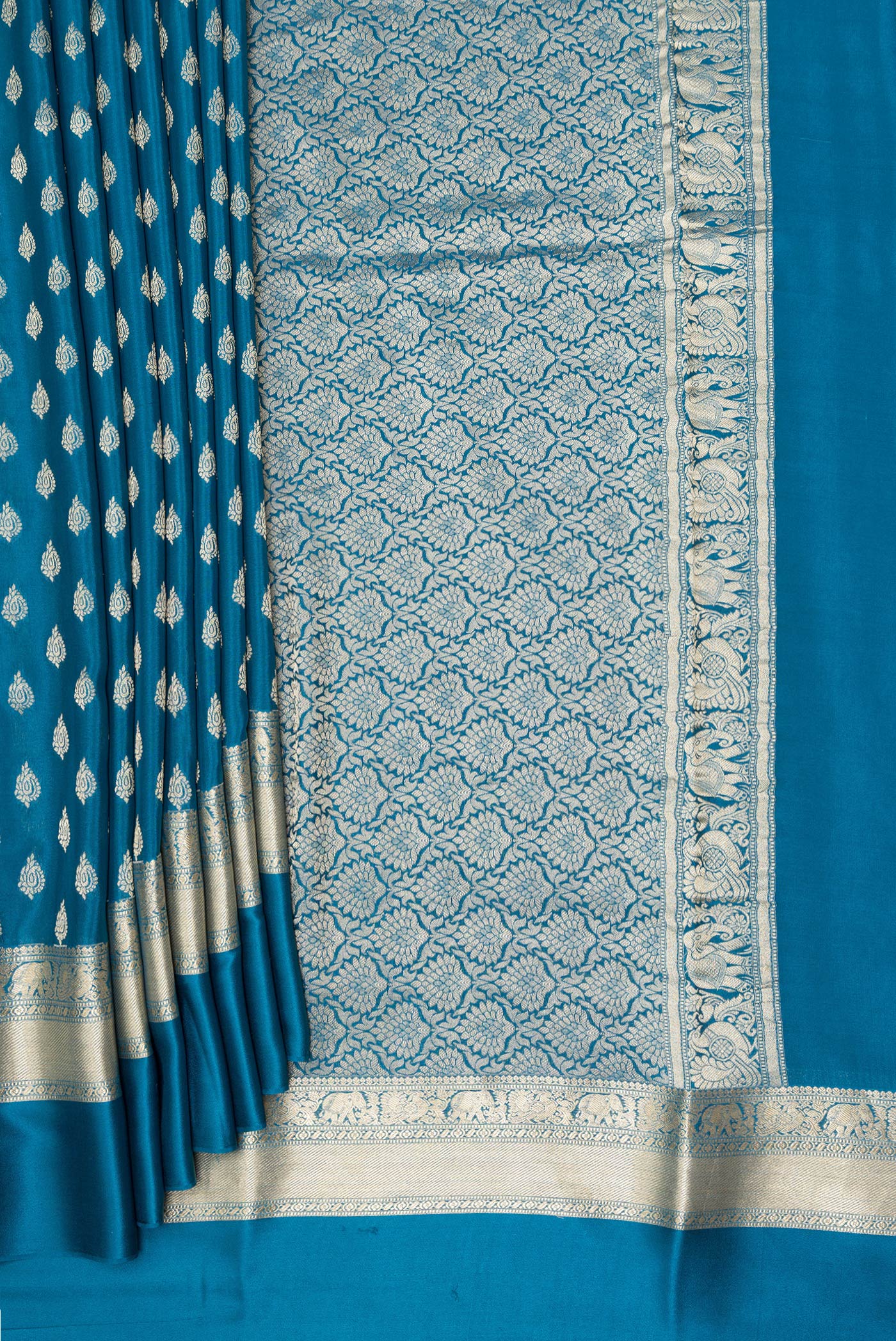 Pleats and pallu of Peacock Blue Mysore Crepe Saree with Zari Butta on the body and Zari Border. 