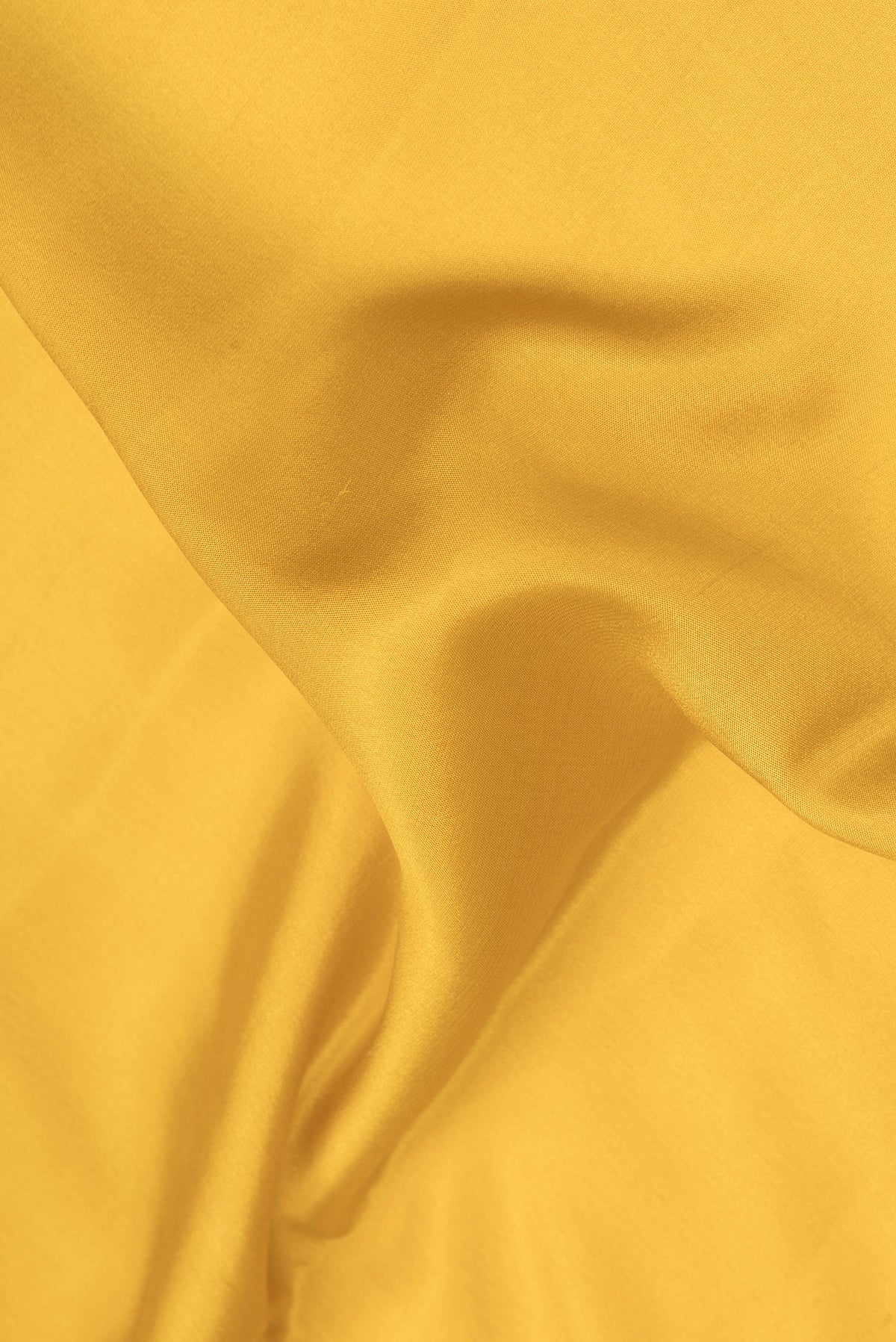 Close up of Mustard Mysore Crepe Saree with Plain Body and Fancy Border.  displaying folds