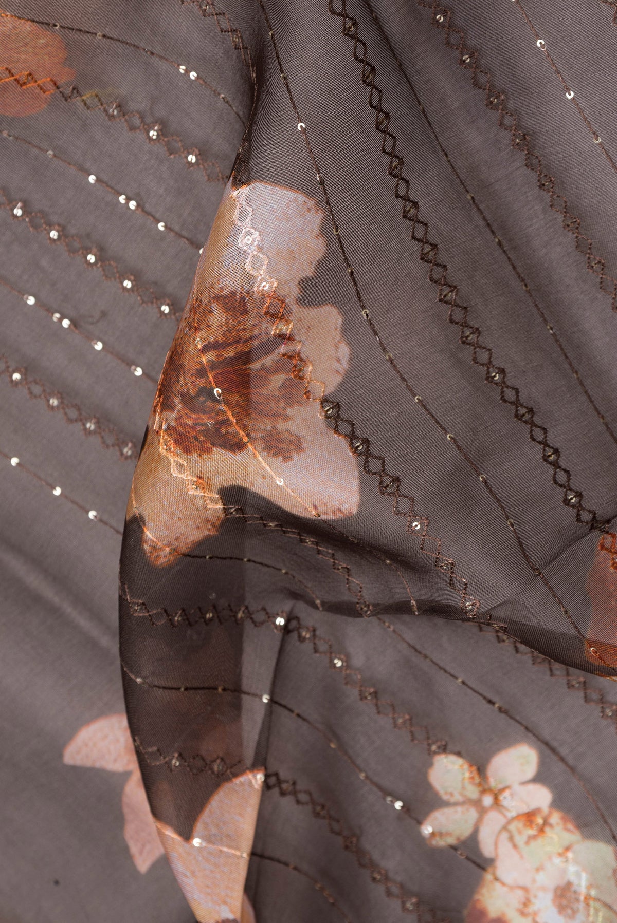 Close up of Brown Dual Tone Organza Silk Saree with Embroidery on the body and Without Border.  displaying folds