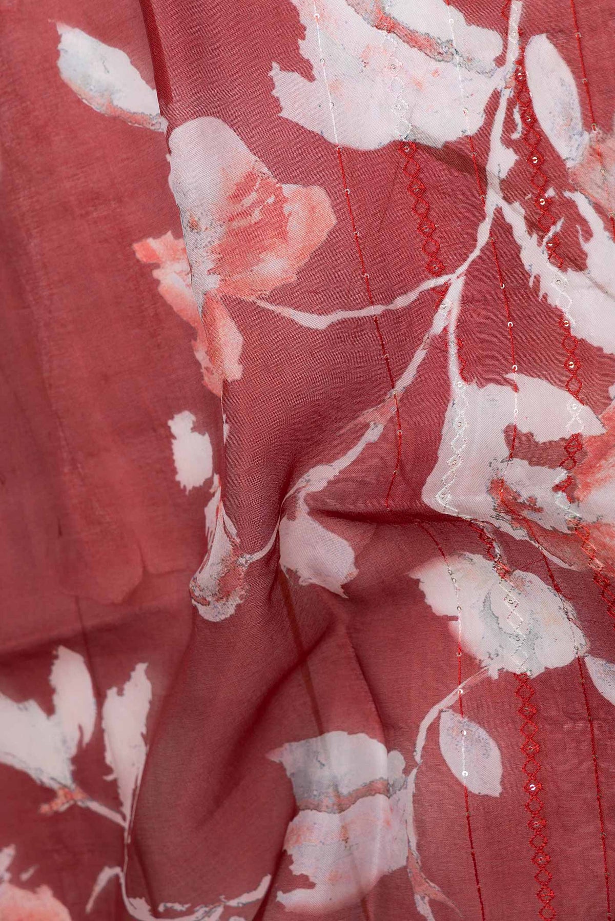Close up of Red Dual Tone Organza Silk Saree with Printed design on the body and Embroidery Border displaying folds