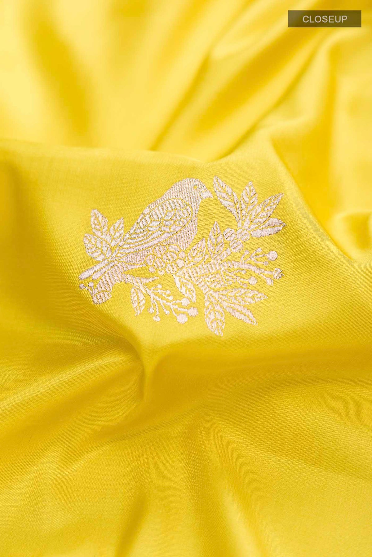 Close up of Yellow Banarasi Silk Saree with Zari Butta on the body and Zari Border displaying folds