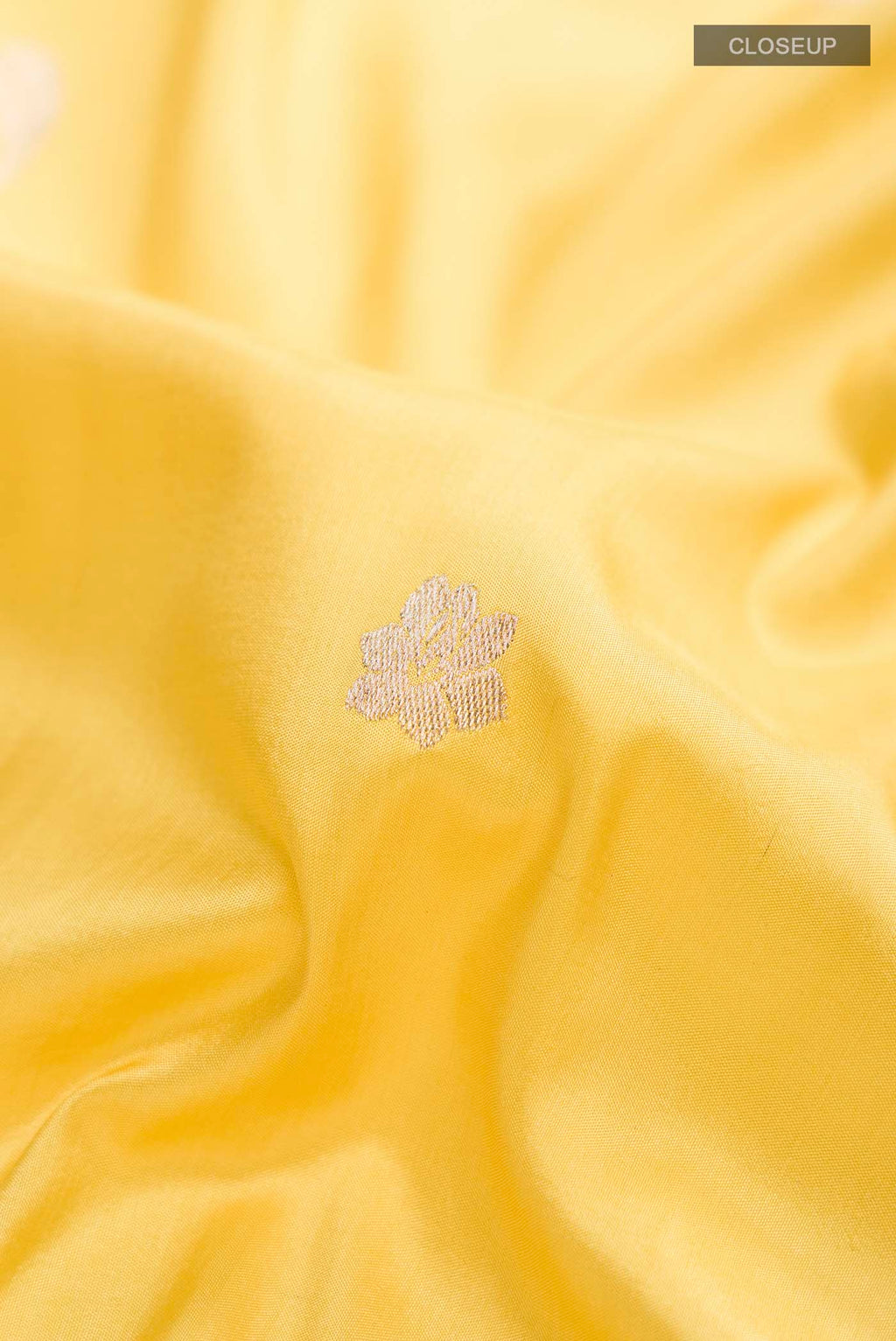 Close up of Yellow Banarasi Silk Saree with Zari Butta on the body and Zari Border displaying folds