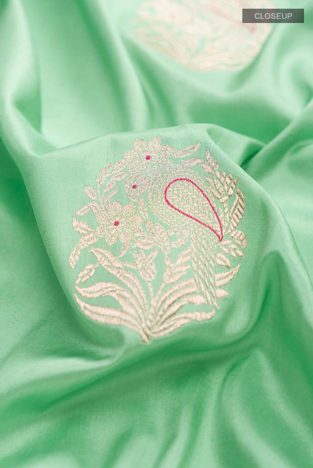 Close up of Green Banarasi Silk Saree with Zari Butta on the body and Zari Border displaying folds