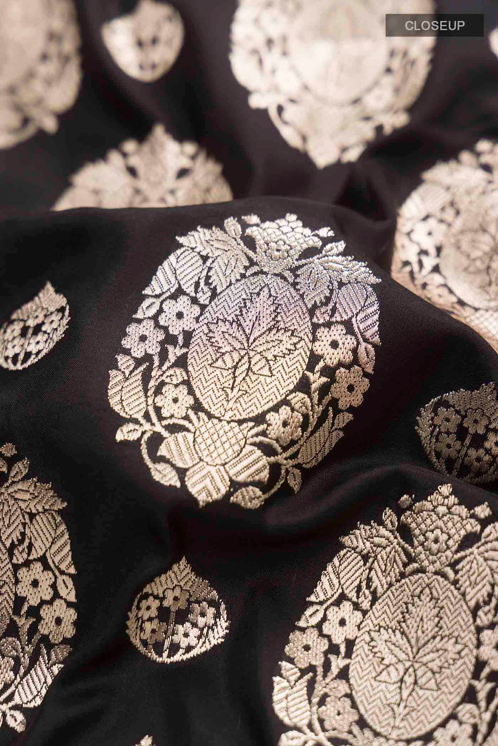 Close up of Black Banarasi Silk Saree with Zari Butta on the body and Zari Border displaying folds