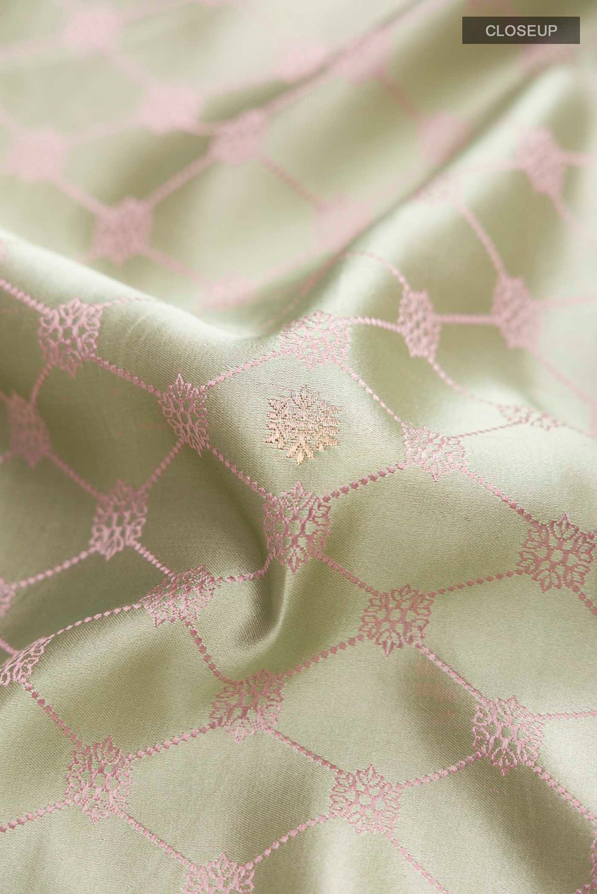 Close up of Green Banarasi Silk Saree with Zari Butta on the body and Zari Border displaying folds