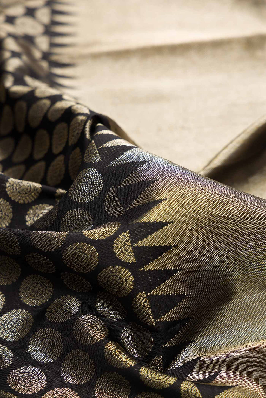 Close up of Black Dual Tone Kanchipuram Silk Saree with Zari Brocade on the body and Zari Border.  displaying folds