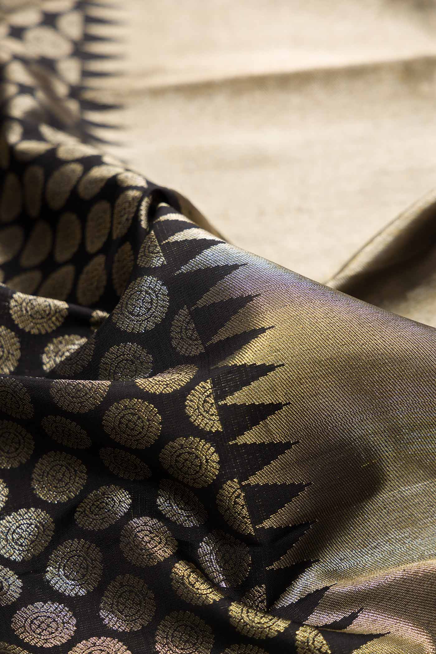 Close up of Black Dual Tone Kanchipuram Silk Saree with Zari Brocade on the body and Zari Border.  displaying folds