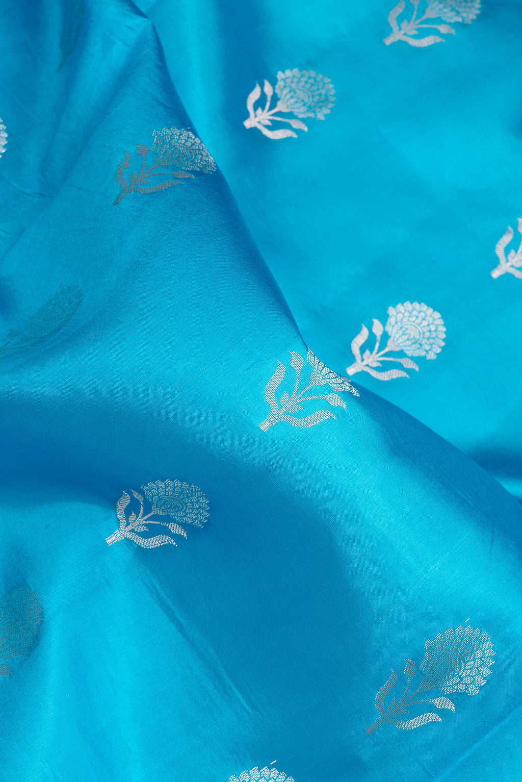 Close up of Sky Blue Dual Tone Tussar Silk Saree with Zari Butta on the body and Fancy Border.  displaying folds
