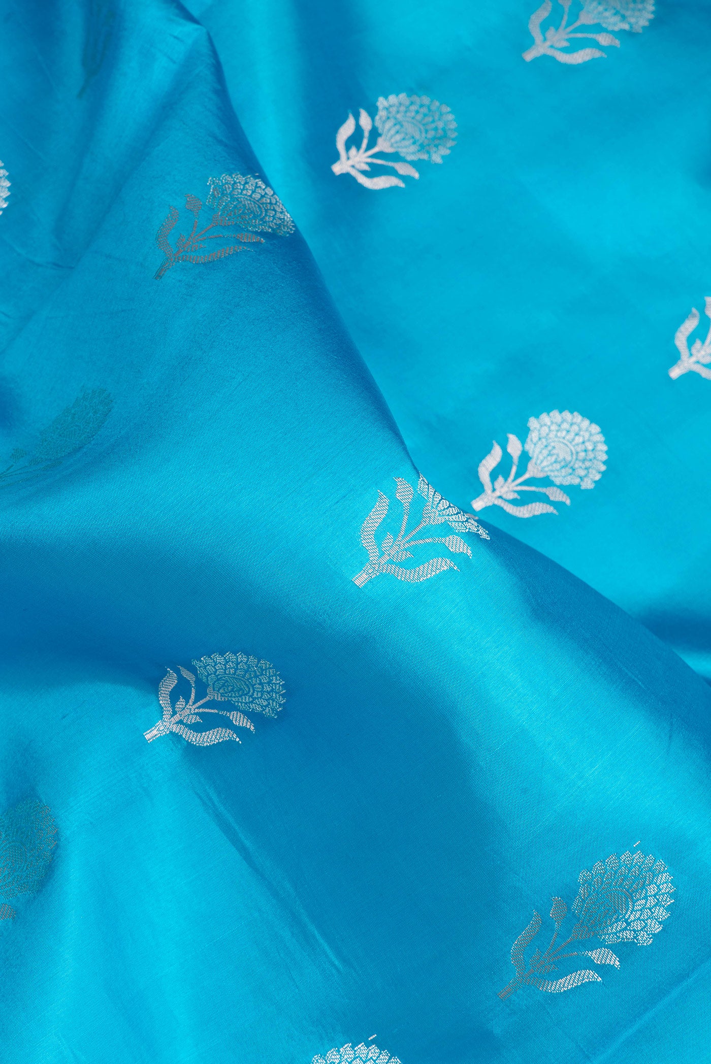 Close up of Sky Blue Dual Tone Tussar Silk Saree with Zari Butta on the body and Fancy Border.  displaying folds