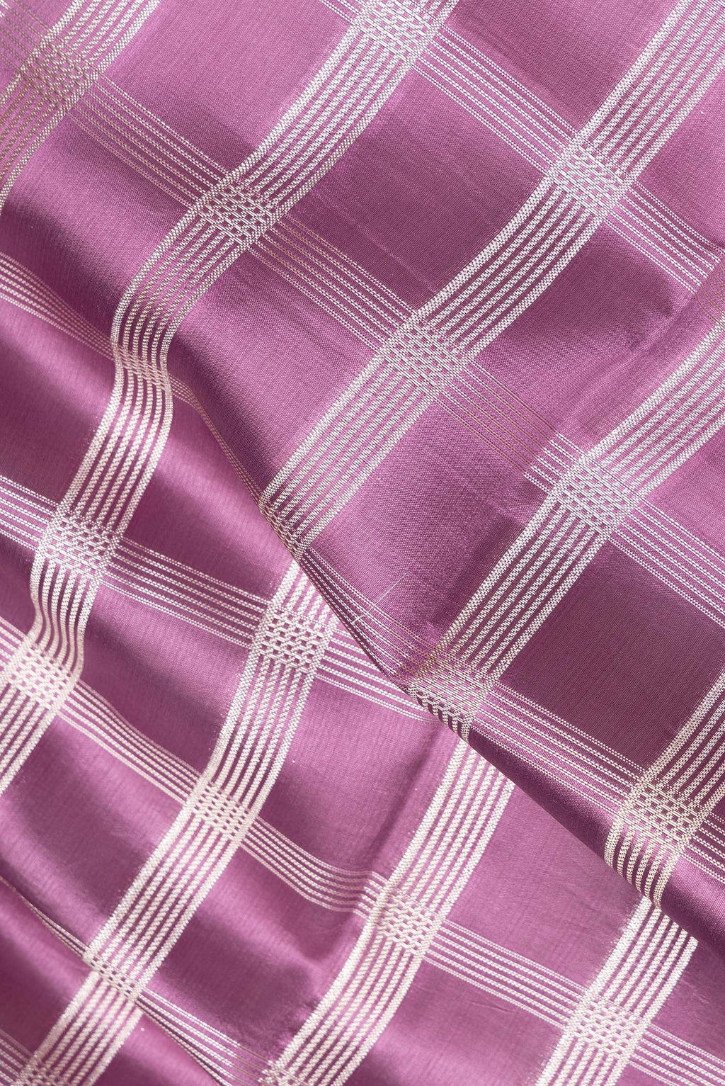 Close up of Pure Silk Purple Dual Tone Tussar Saree with Checked design on the body and Fancy Border.  displaying folds