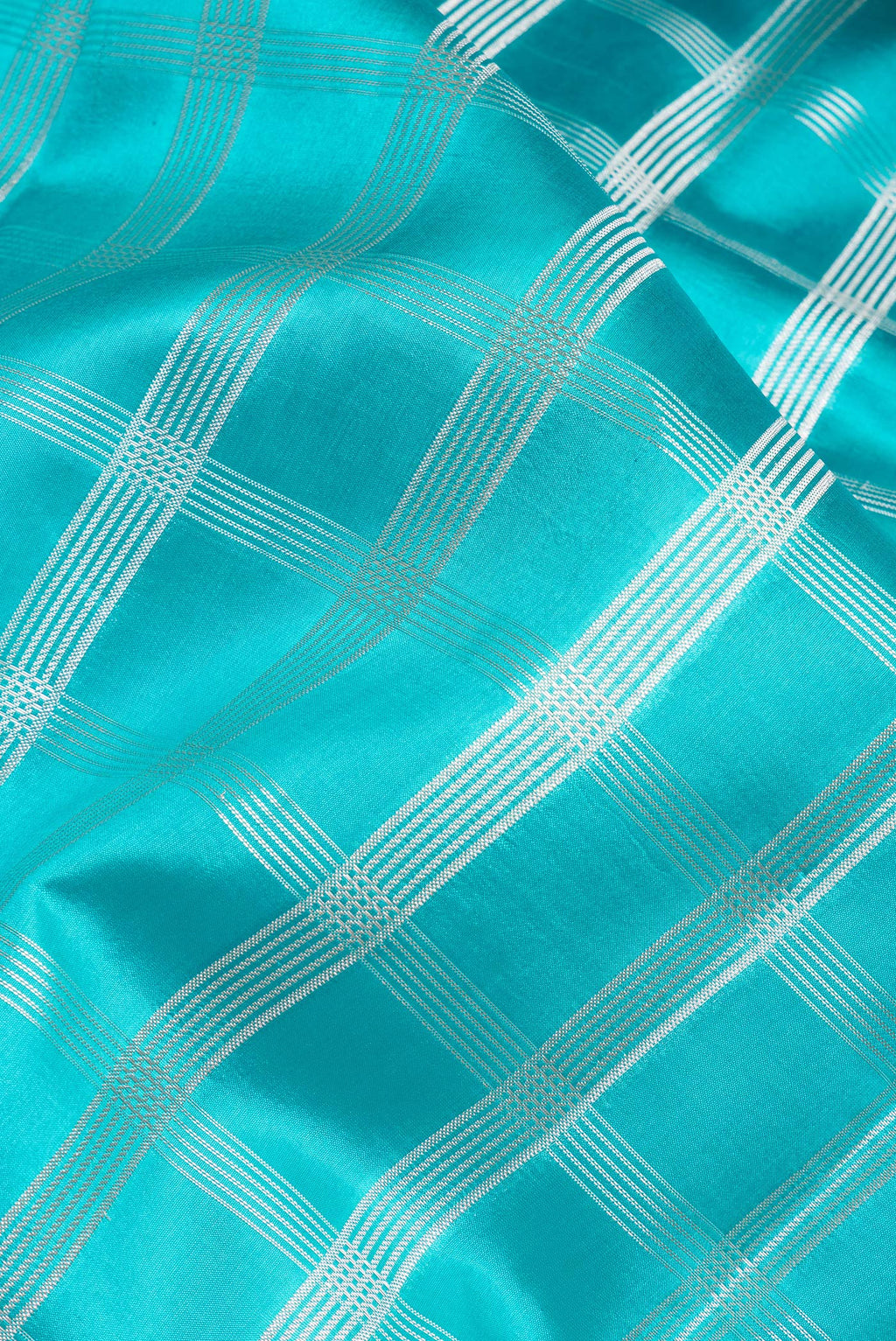 Close up of Sky Blue Dual Tone Tussar Silk Saree with Checked design on the body and Fancy Border.  displaying folds