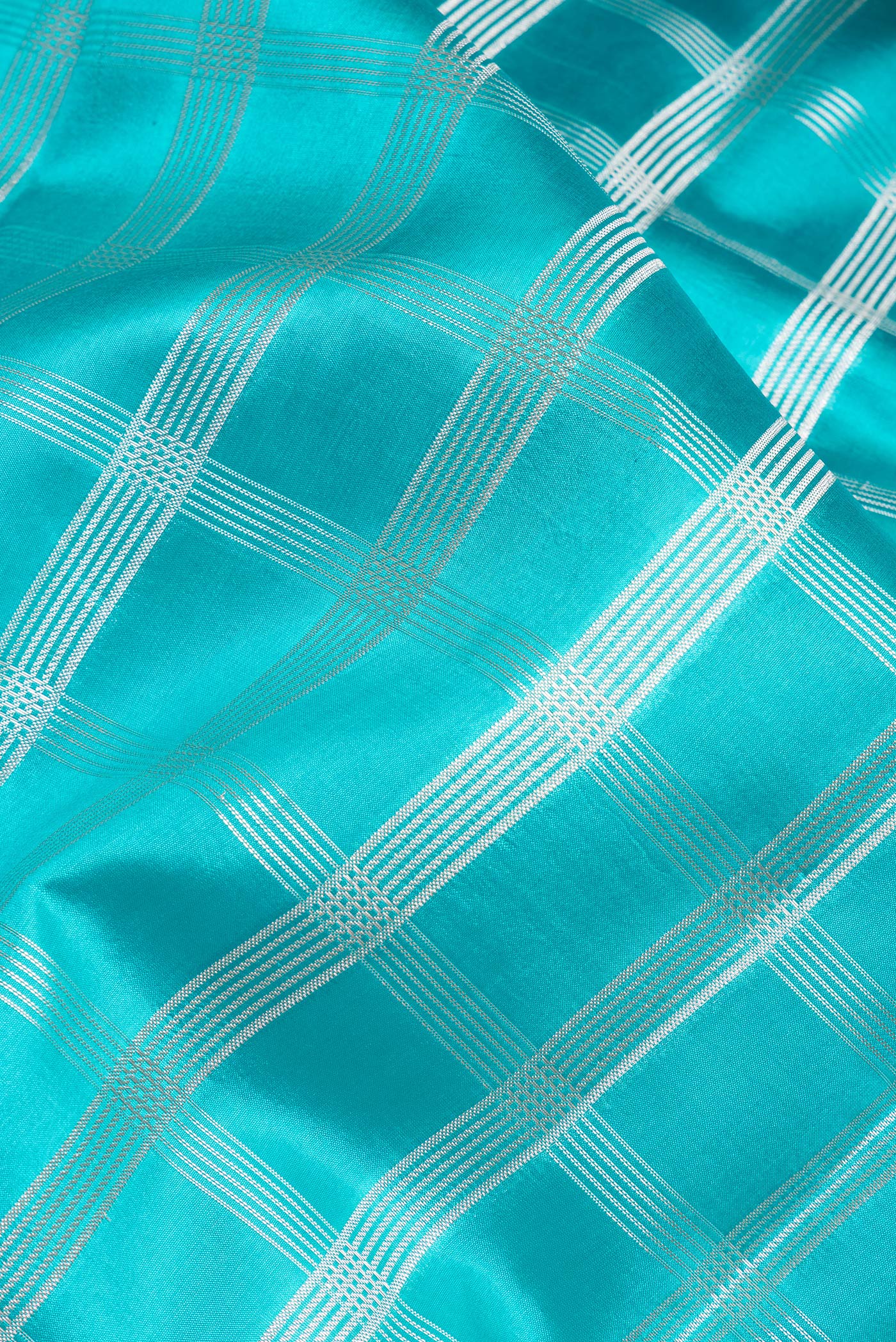 Close up of Sky Blue Dual Tone Tussar Silk Saree with Checked design on the body and Fancy Border.  displaying folds