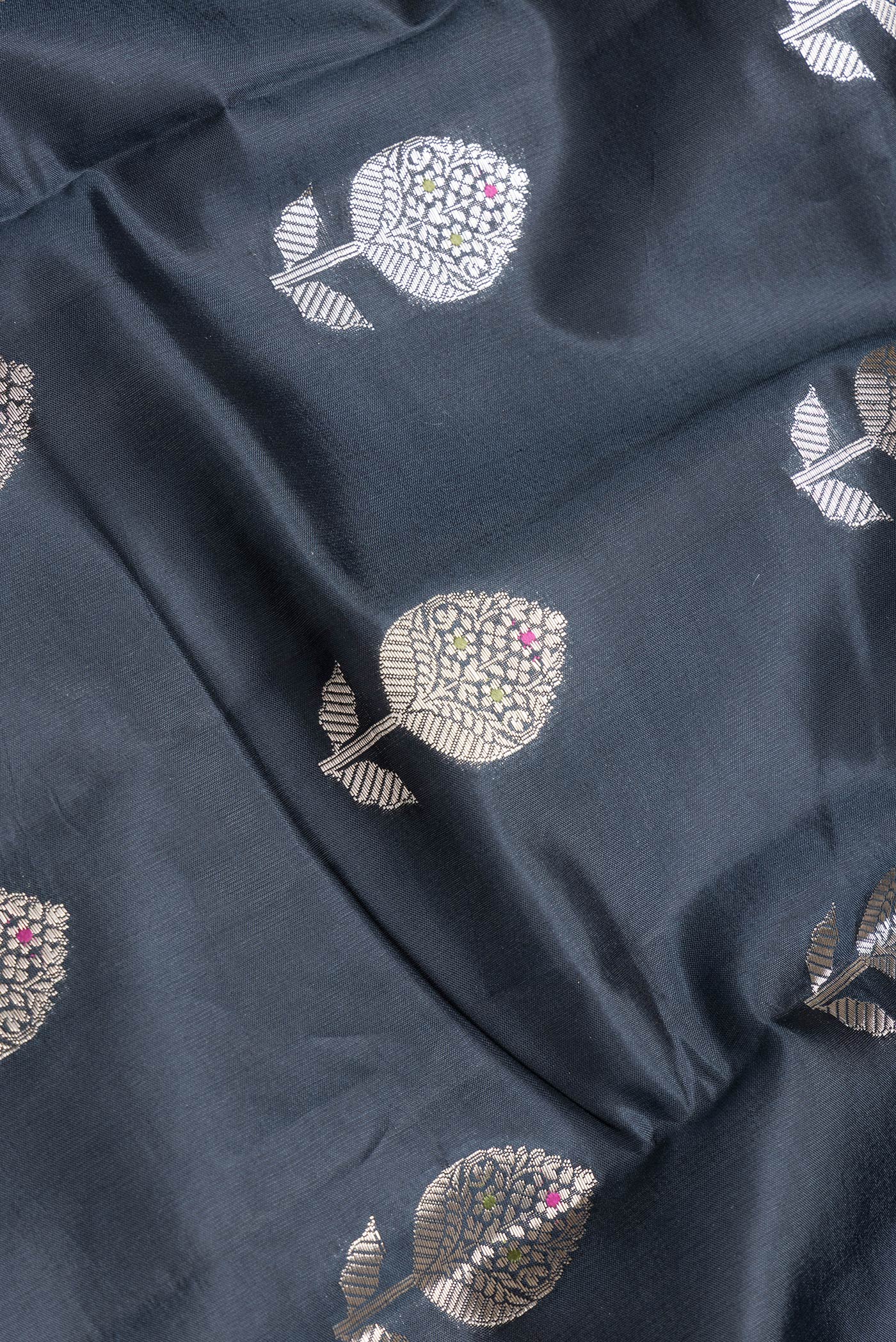 Close up of Black Dual Tone Tussar Silk Saree with Zari Butta on the body and Fancy Border.  displaying folds