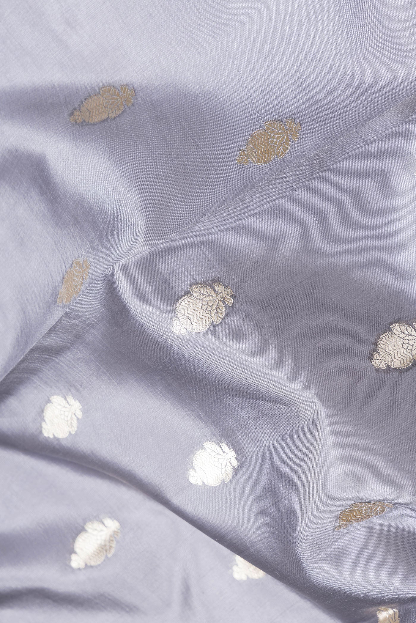 Close up of Grey Dual Tone Tussar Silk Saree with Zari Butta on the body and Zari Border.  displaying folds