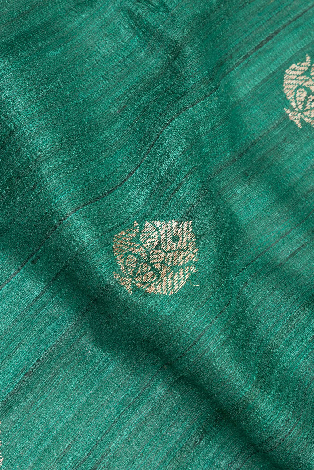 Close up of Green Tussar Saree with Zari Butta on the body and Fancy Border.  displaying folds