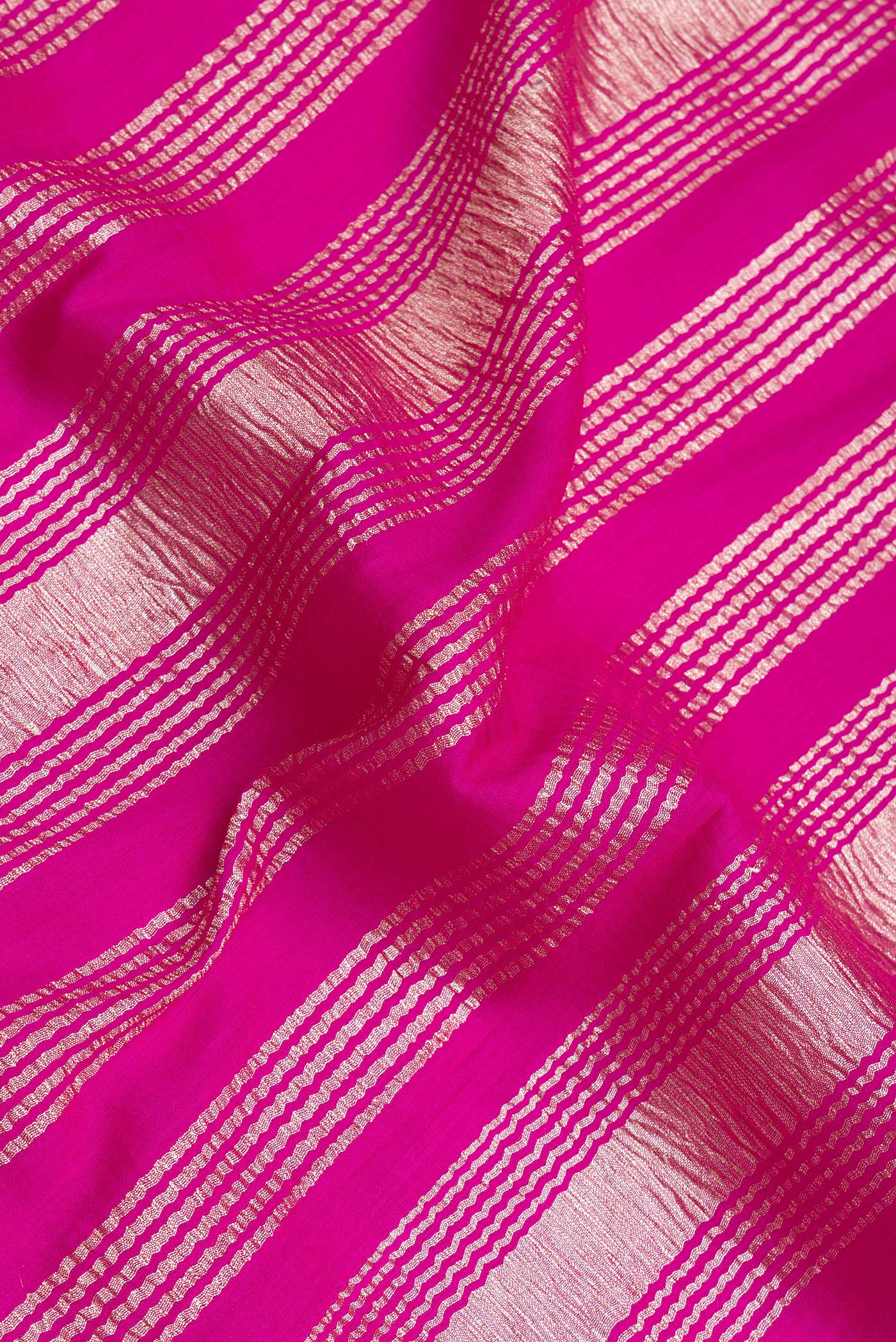 Close up of Rani Pink Tussar Silk Saree with Stripes on the body and Zari Border.  displaying folds
