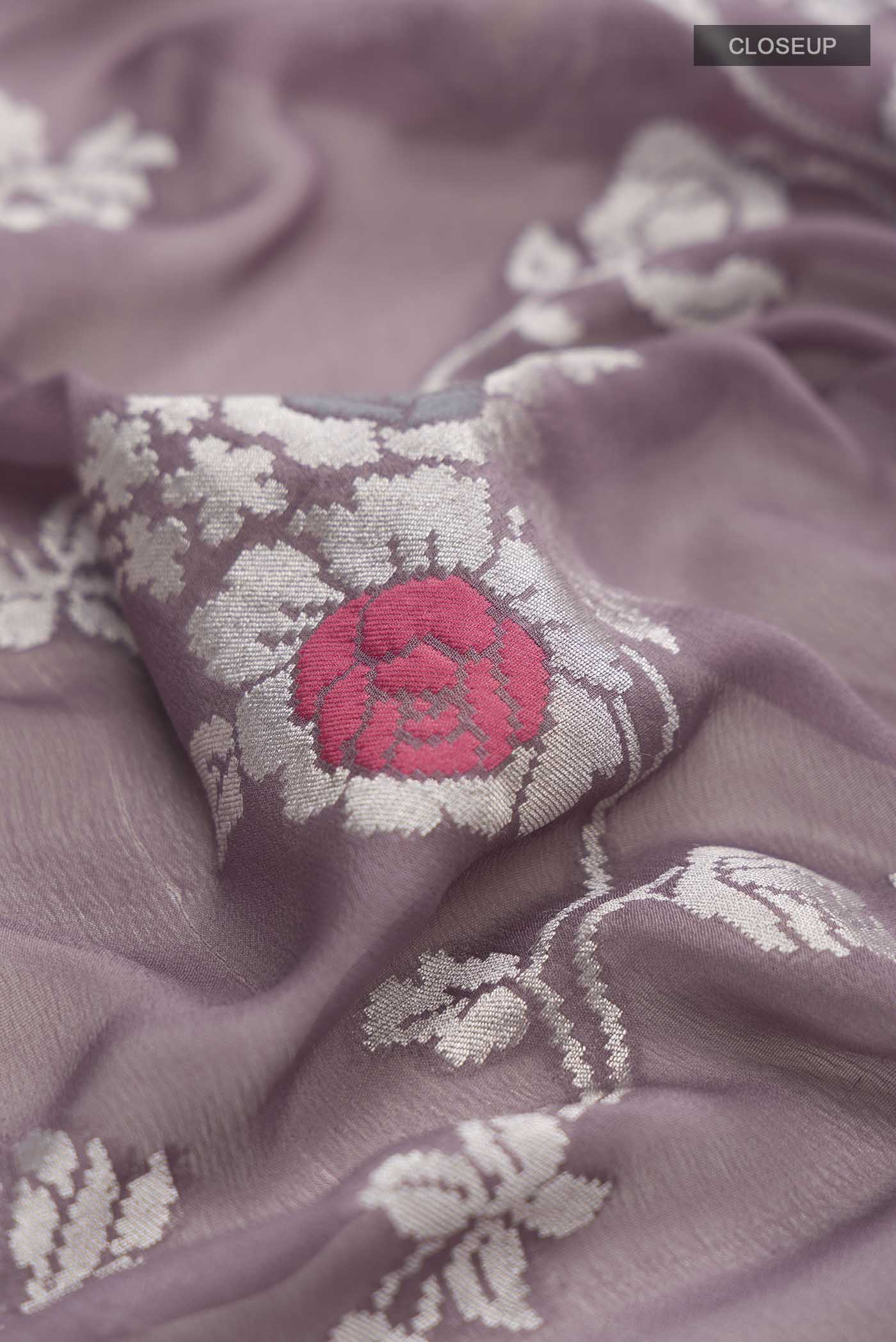 Close up of Lilac Banarasi Georgette Saree with Zari Butta on the body and Zari Border displaying folds
