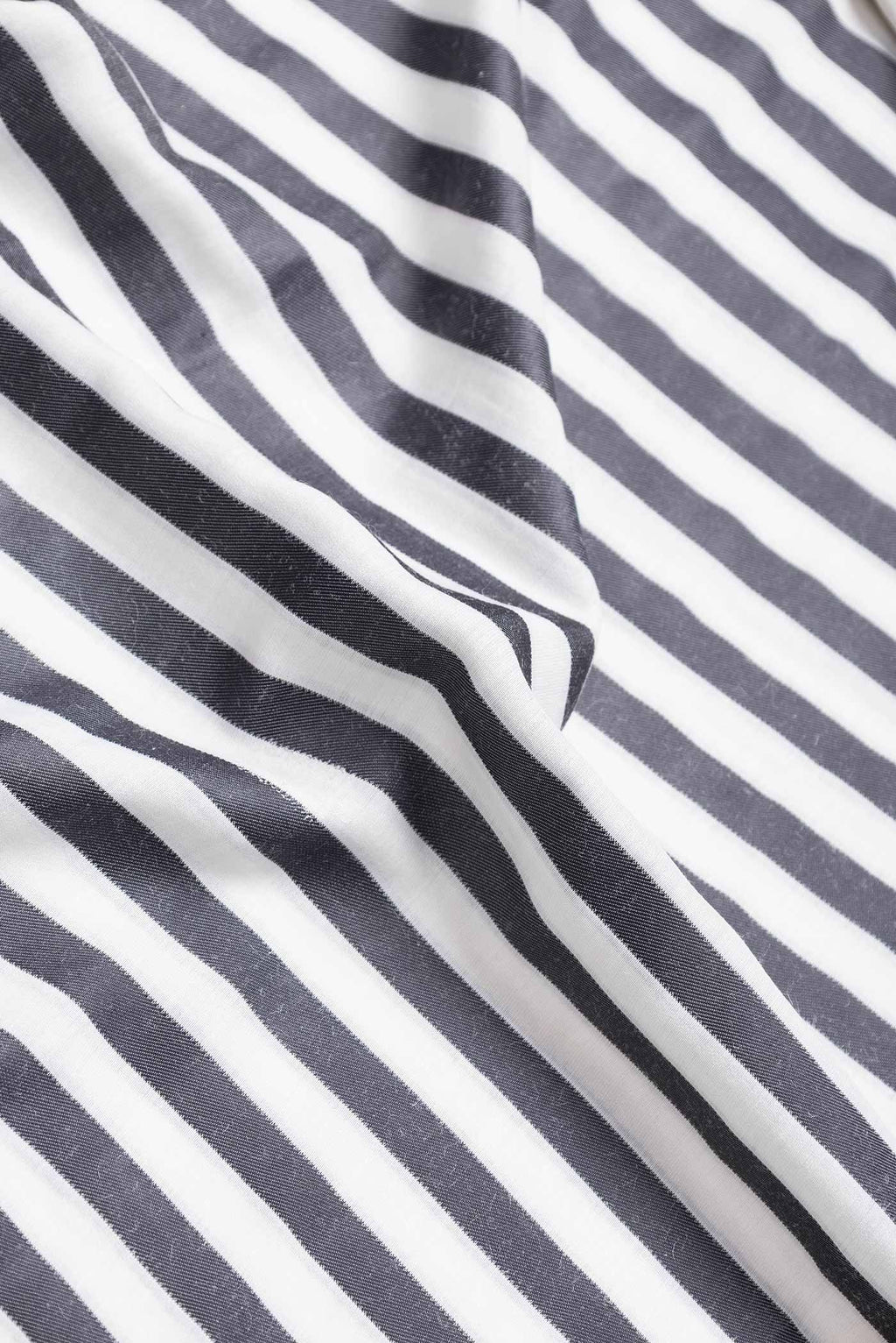 Close up of Off White and Black Color Banarasi Saree with Stripes on the body and Plain Border.  displaying folds