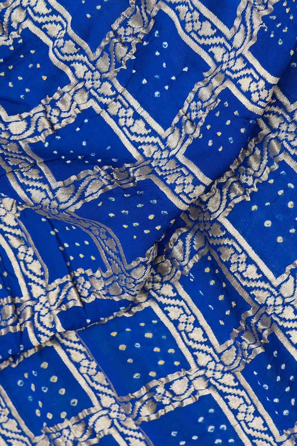 Close up of Royal Blue Bandhani Georgette Saree with Zari Brocade on the body and Zari Border.  displaying folds