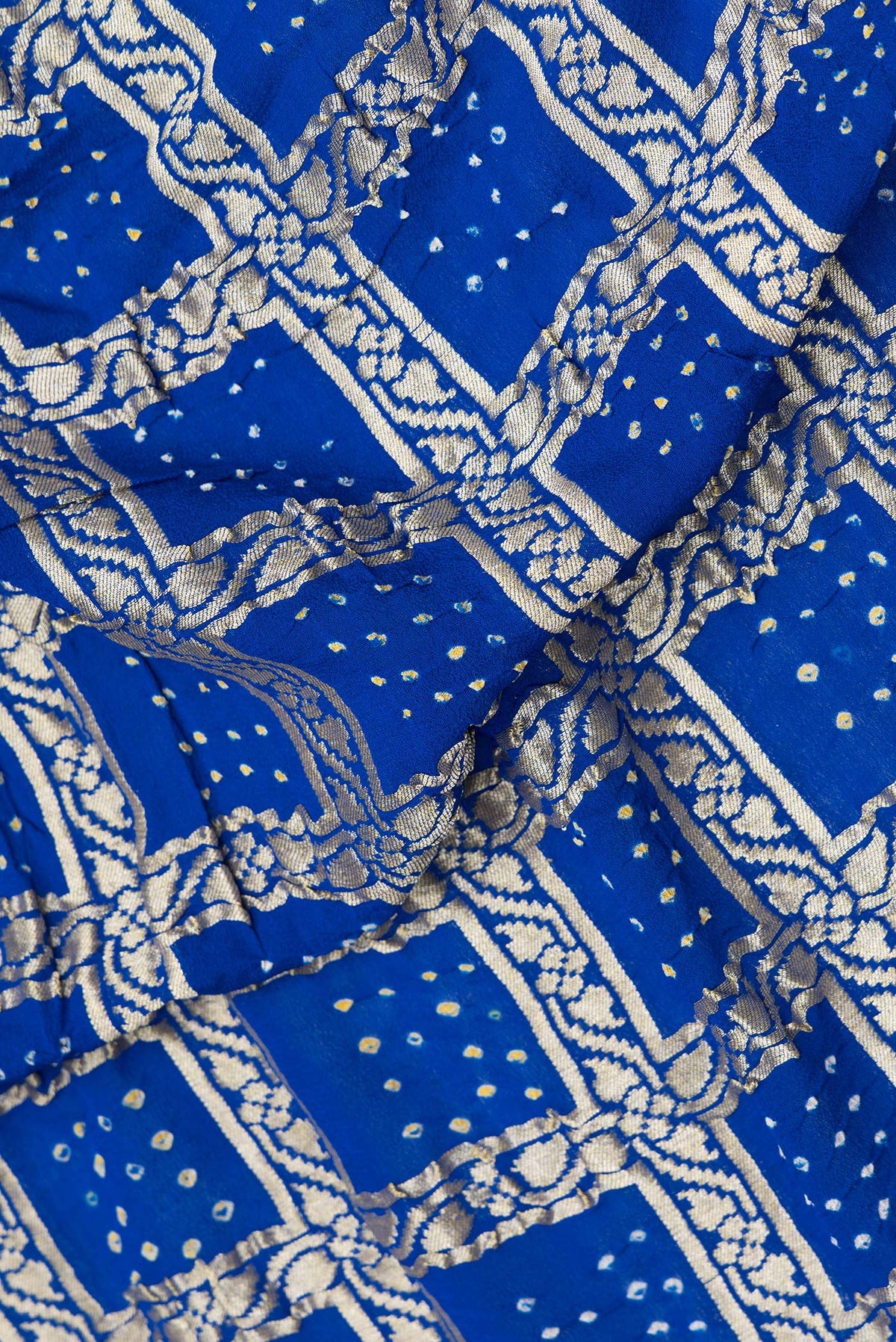 Close up of Royal Blue Bandhani Georgette Saree with Zari Brocade on the body and Zari Border.  displaying folds