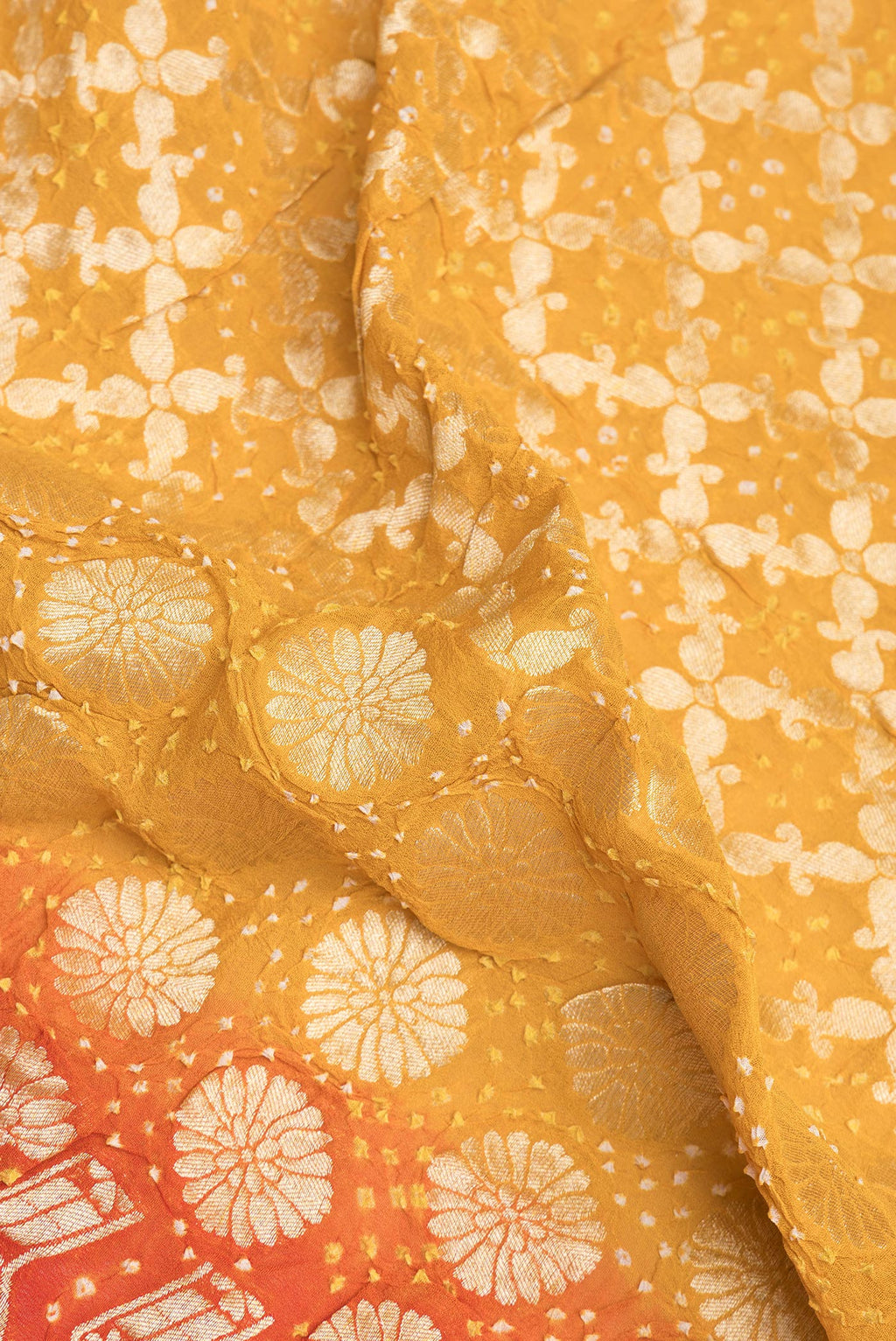 Close up of Yellow Bandhani Georgette Saree with Zari Brocade on the body and Zari Border.  displaying folds