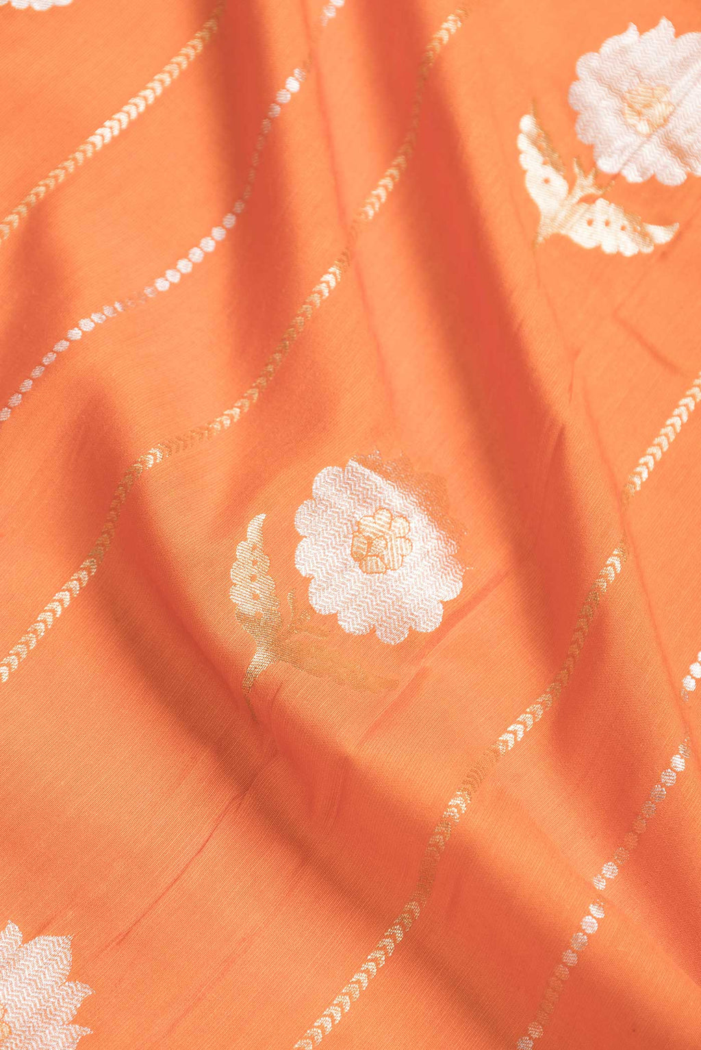 Close up of Orange Dual Tone Banarasi Saree with Zari Brocade on the body and Plain Border.  displaying folds