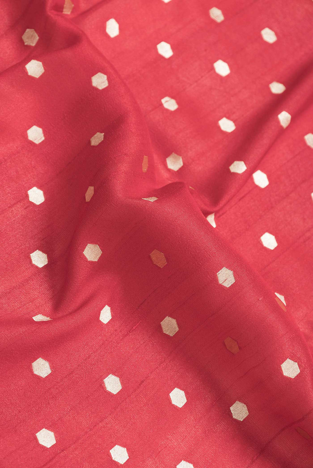 Close up of Red Dual Tone Tussar Saree with Zari Butta on the body and Fancy Border.  displaying folds