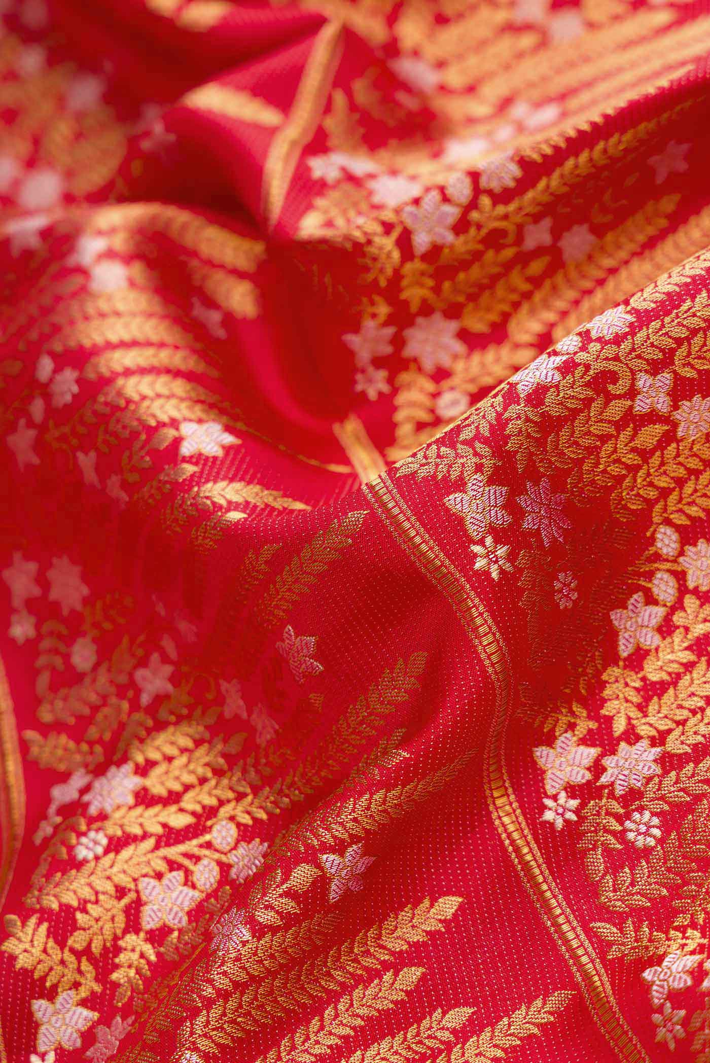 Close up of Red Dual Tone Kanjivaram Silk Saree with Zari Brocade on the body and Fancy Border.  displaying folds