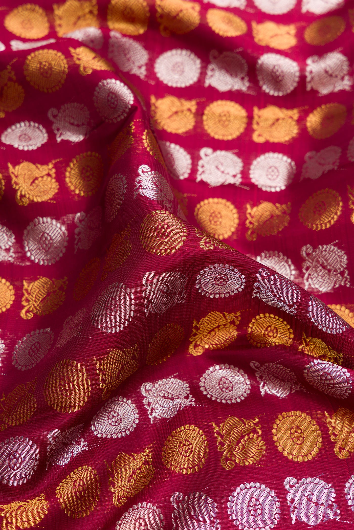 Close up of Maroon Dual Tone Kanchipuram Silk Saree with Zari Brocade on the body and Zari Border.  displaying folds