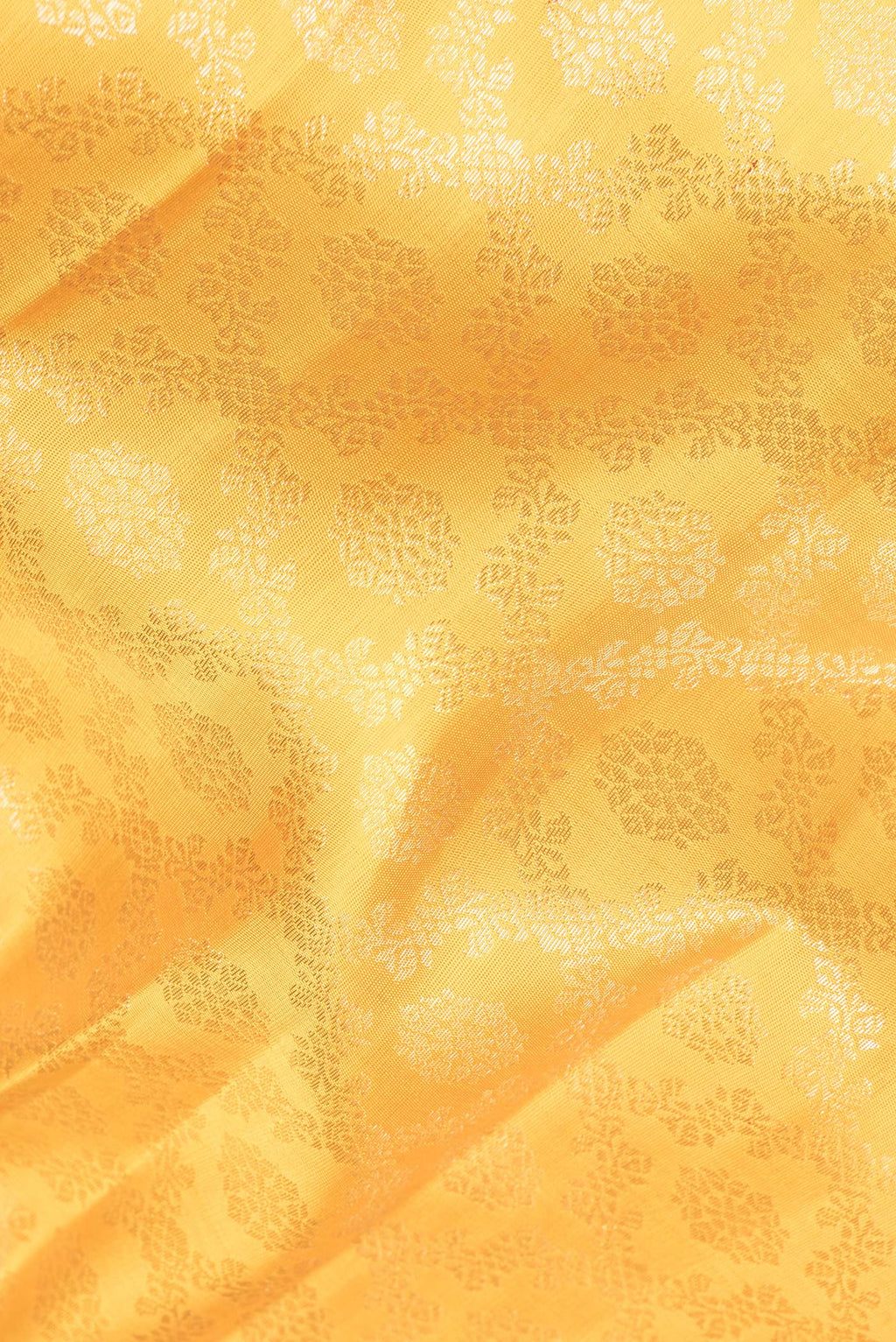 Close up of Pure Silk Yellow Kanchipuram Saree with Zari Brocade on the body and Zari Border.  displaying folds