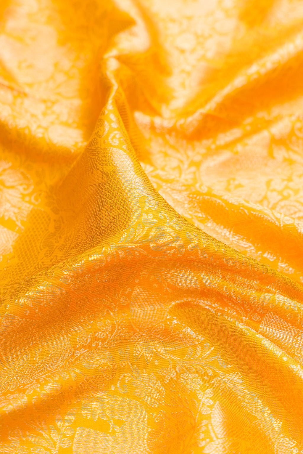 Close up of Yellow Kanchipuram Silk Saree with Zari Brocade on the body and Zari Border.  displaying folds