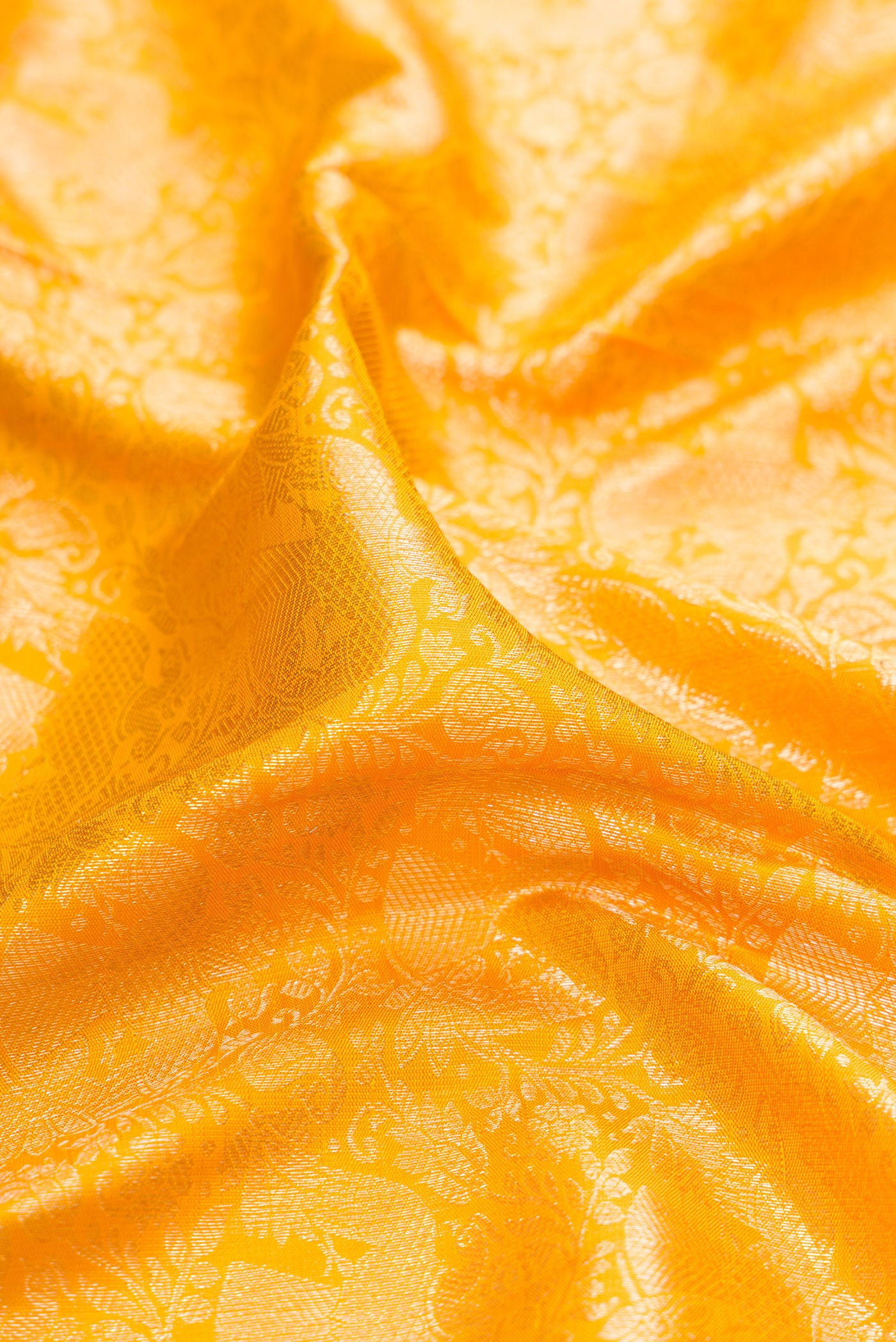 Close up of Yellow Kanchipuram Silk Saree with Zari Brocade on the body and Zari Border.  displaying folds