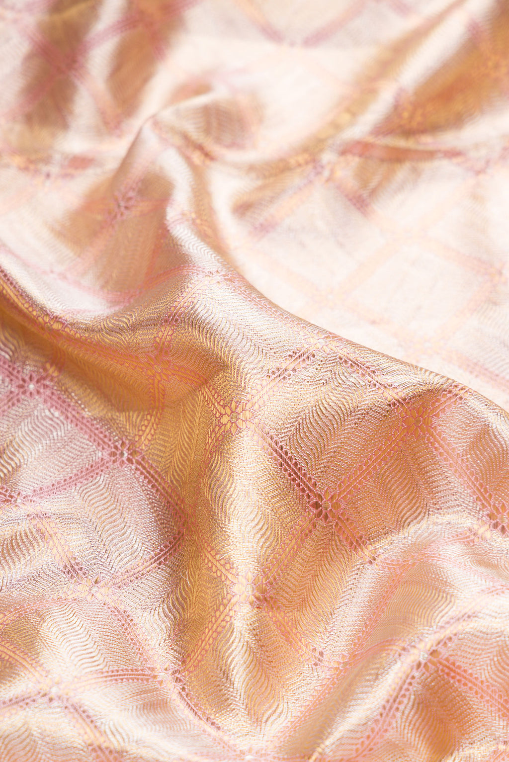 Close up of Rose Gold Dual Tone Kanjivaram Tissue Silk Saree with Zari Brocade on the body and Zari Border.  displaying folds